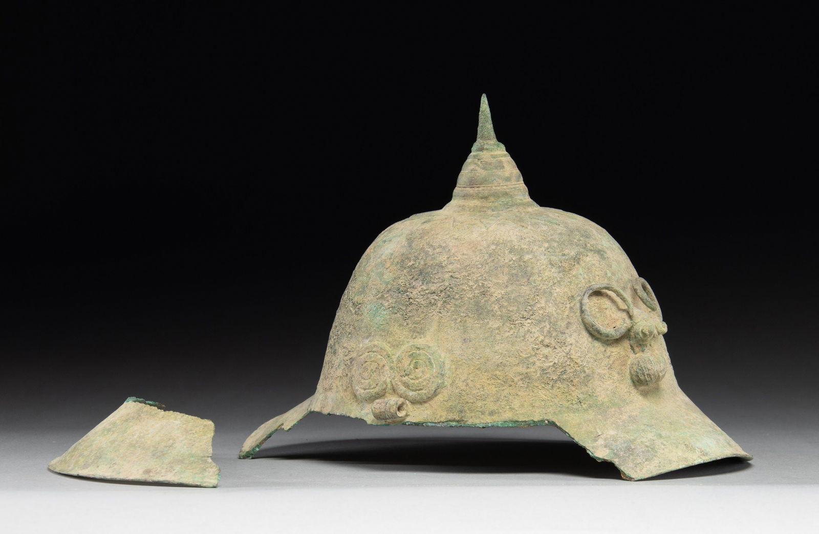 EARLY VIETNAMESE BRONZE CEREMONIAL HELMET.: A very interesting Vietnamese ceremonial bronze helmet likely dating from the Dong Son period (800BC to 200AD). The helmet is bronze and stands about 7 1/2" high and measures 9 3/4 inches from front t