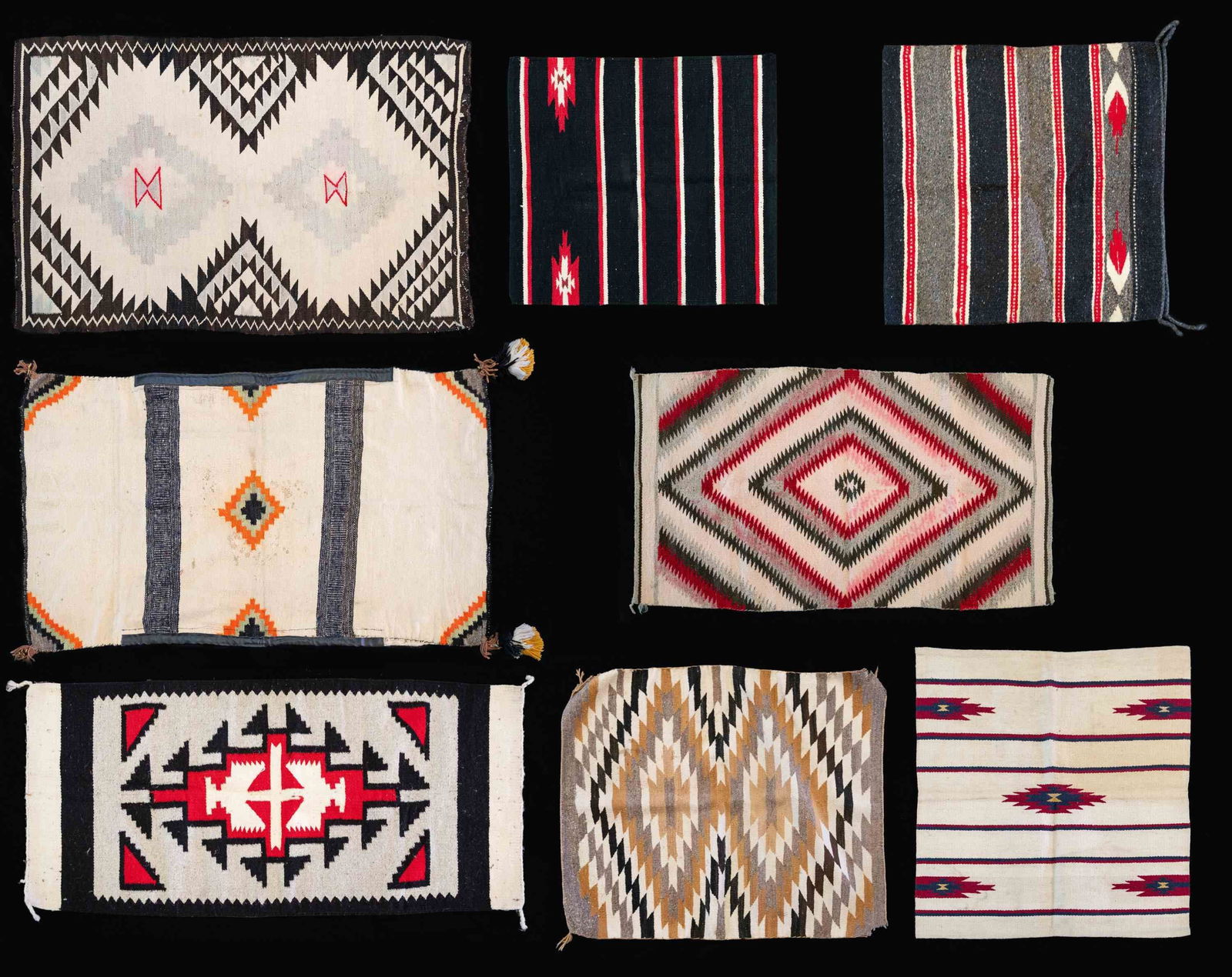 GROUPING OF 8 NAVAJO THEMED RUGS.: All 8 cotton & wool rugs are approx. 52" x 32" with different colors & patterns. These patterns appear to be shown in "NAVAJO RUGS" by Gilbert Maxwell book included with this lot. CONDITION: rugs in g