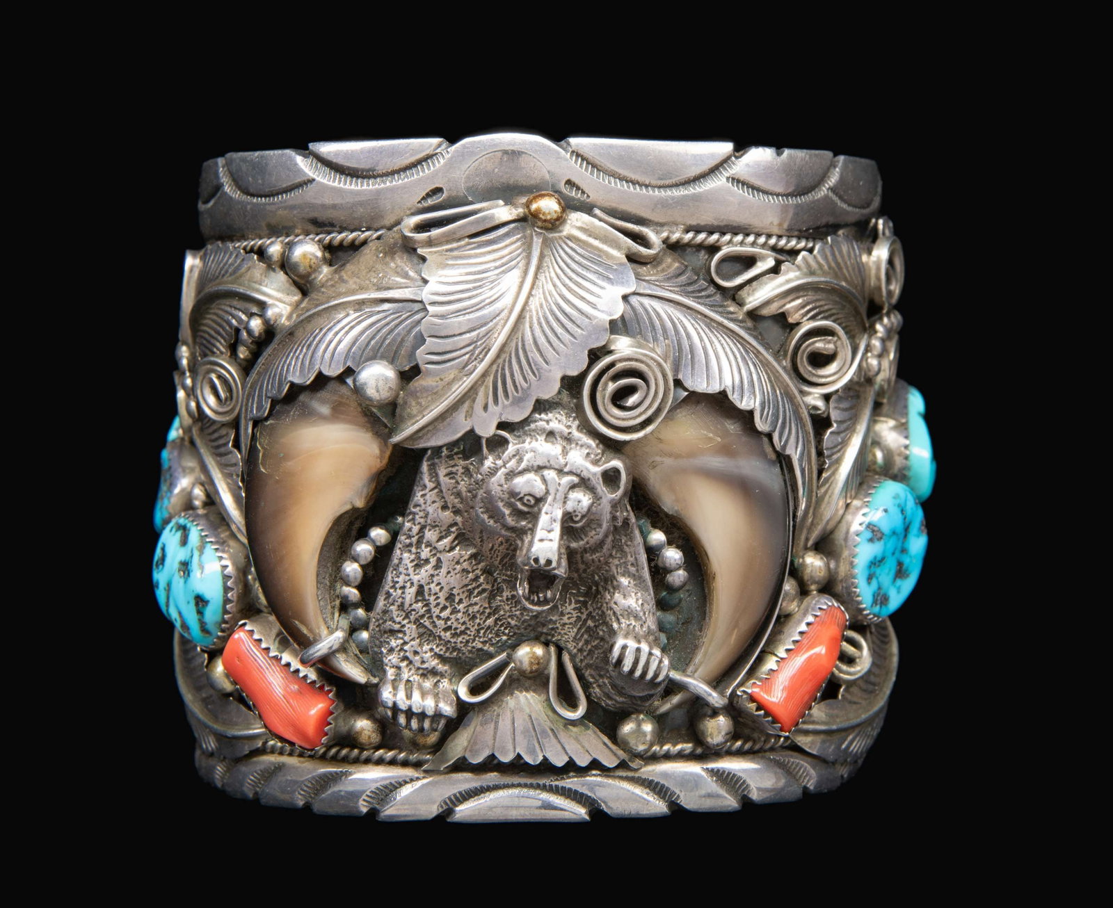 LARGE “MIKE THOMAS, JR?? SIGNED STERLING NAVAJO: TURQUOISE, RED CORAL & BEAR CLAW BRACELET. 3" wide heavy sterling bracelet decorated with a bear claw, silver relief bear, red coral & turquoise, signed "M. Thomas, Jr", 170 grams. CONDITION: good. (0