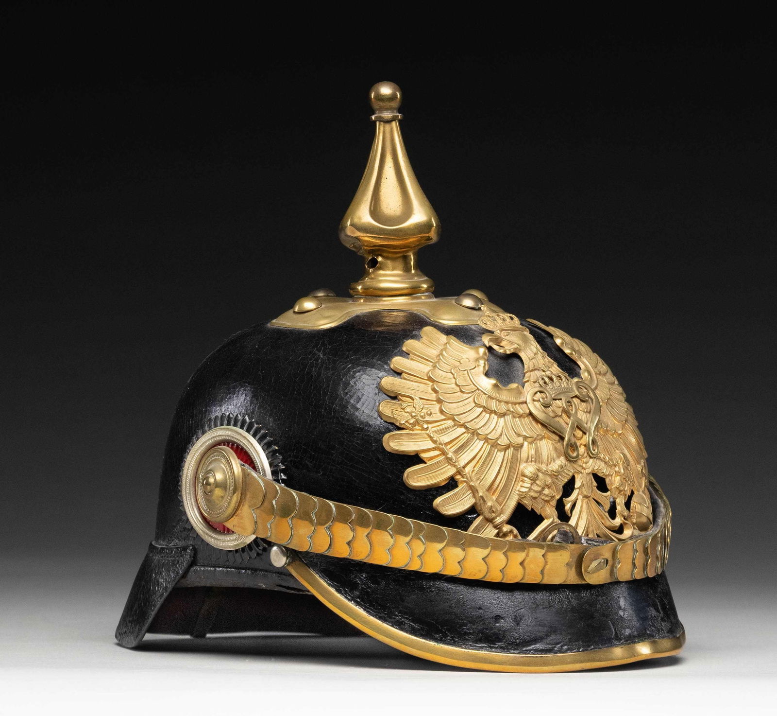 PRUSSIAN CUSTOMS OFFICER PICKELHAUBE.: Prussian Customs officer pickelhaube helmet. Wappen features a Prussian eagle with crown & "W" for Kaiser Wilhelm II. Helmet is of black leather construction with brass spike & hardware. Prussian & Im