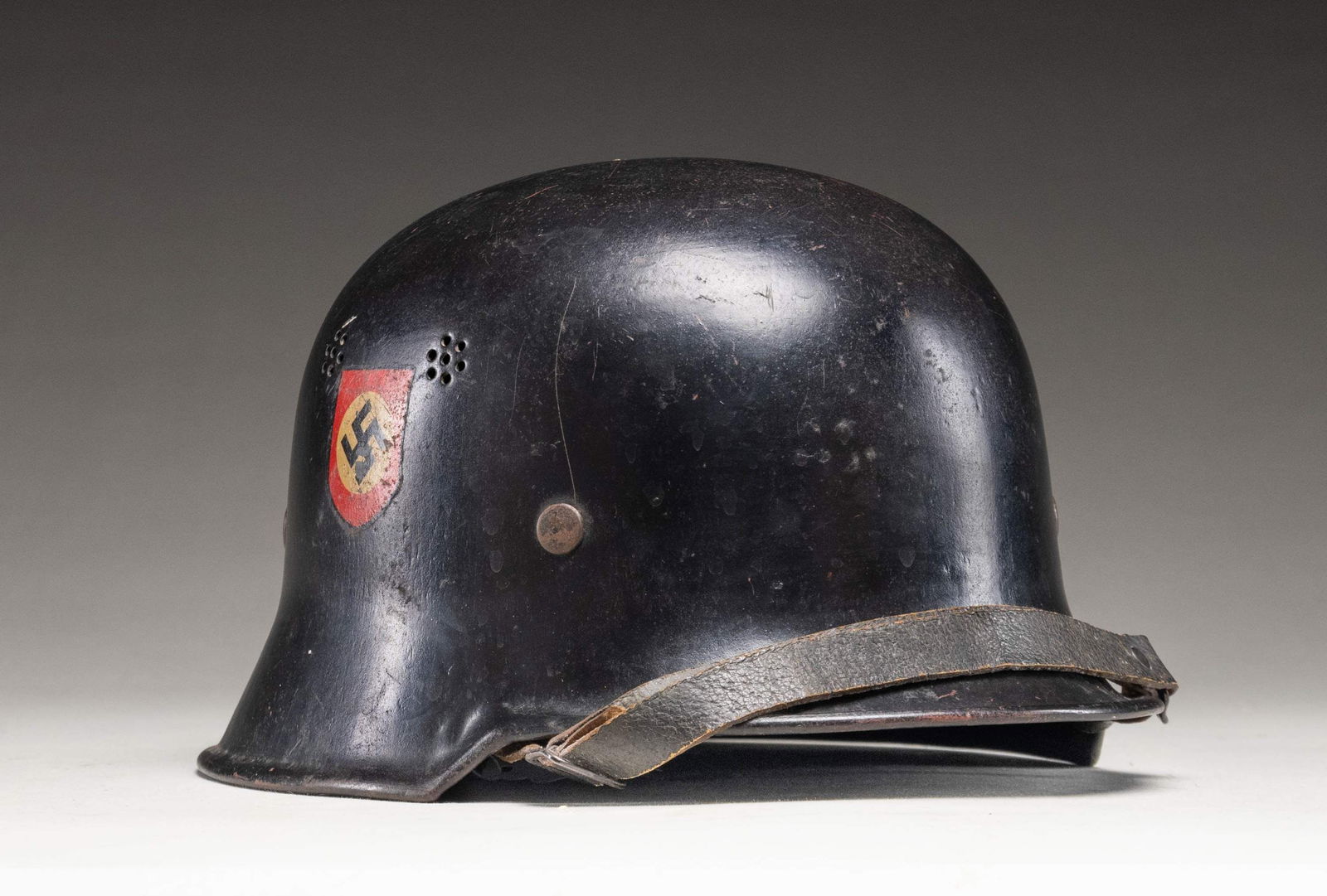 WWII GERMAN POLICE HELMET.: A very fine example of a WWII German civic style Police helmet with a black painted finish featuring a Police decal on the left side and a Party decal on the right side. The inside rear is stamped " T