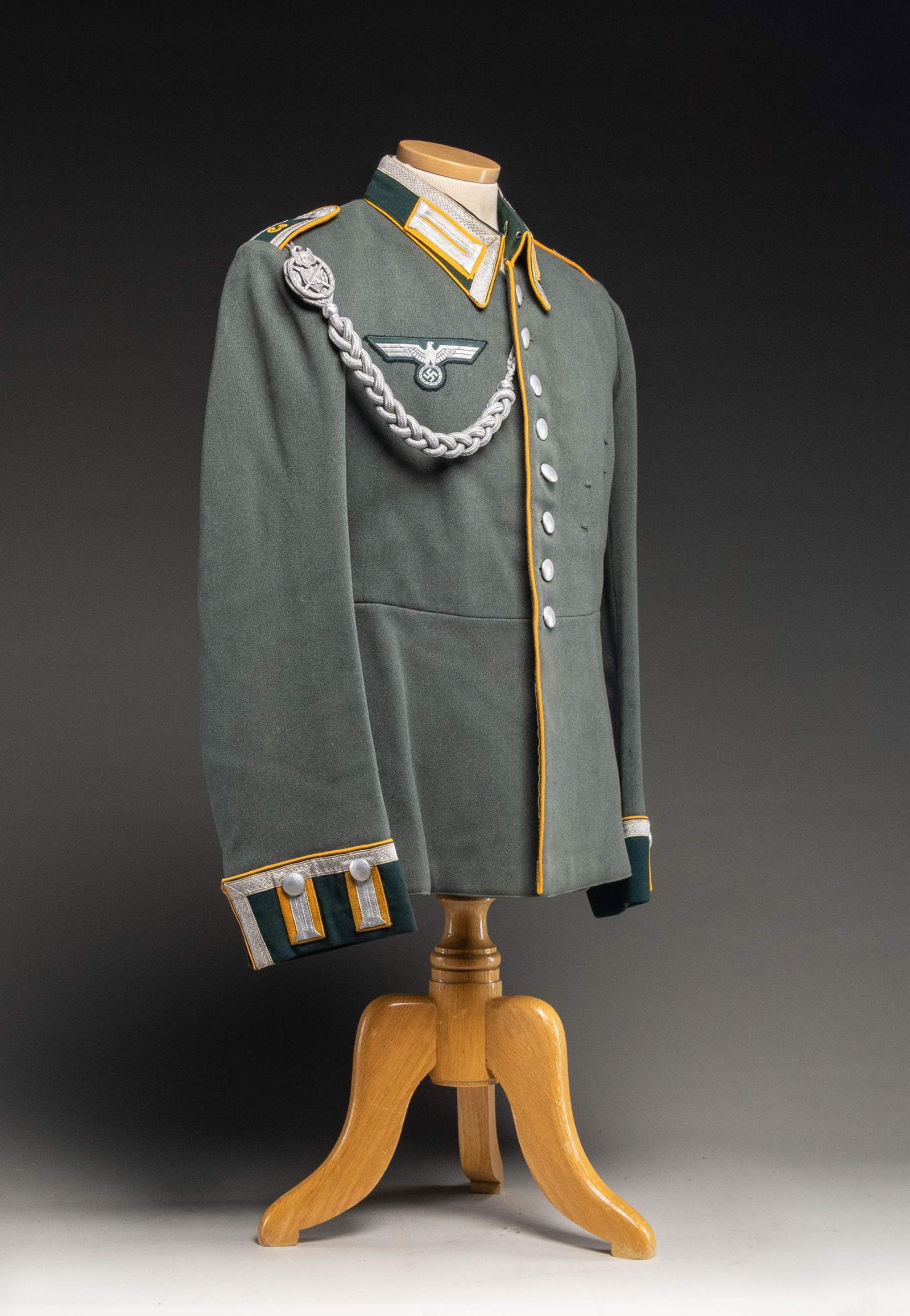 WWII GERMAN WEHRMACHT CAVALRY OFFICER'S TUNIC.: A deep sage green tunic with a dark green collar piped in yellow with silver tape on yellow collar tabs. The shoulder straps are enlisted bordered in yellow with an embroidered yellow "3" and silver b