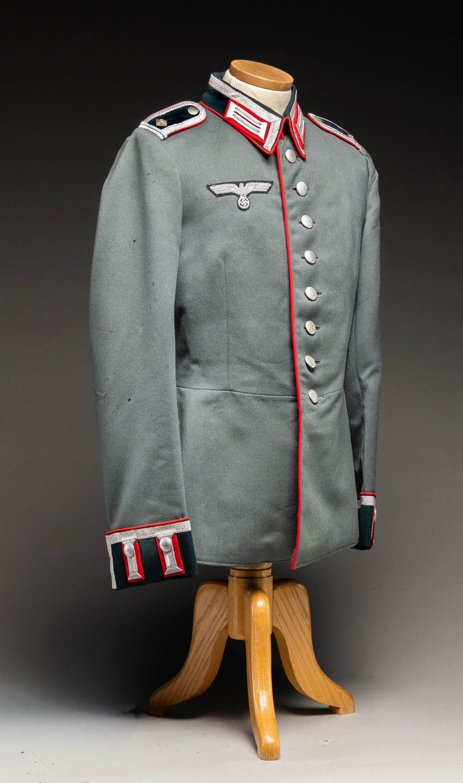 WWII GERMAN ARTILLERY DRESS TUNIC FOR A SERGEANT: MAJOR. A deep sage green tunic with a dark green collar piped in red with silver tape bullion borders for a Sergeant Major of the Wehrmacht Artillery. Collar tabs are silver bullion on a red field. Th
