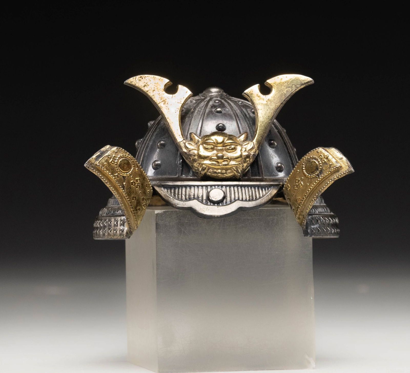 JAPANESE SAMURAI HELMET INKWELL.: This impressive inkwell measures approximately 2 1/2" x3 1/2" and emulates an Edo period Japanese Samurai helmet. The body of the helmet has a plated finish with a crest on the front and flaps being