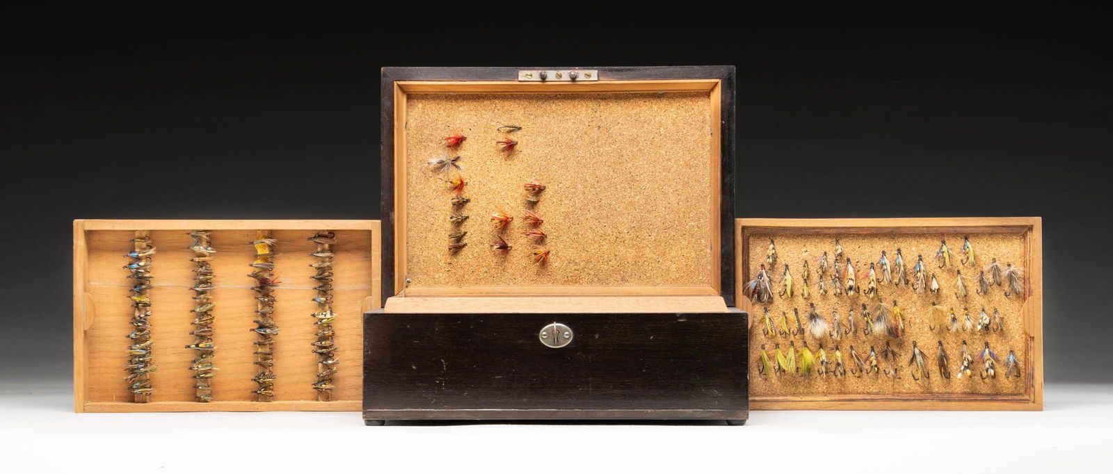 SUPERB ANTIQUE WOODEN FLY BOX CONTAINING APPROX.: 200 VINTAGE FLIES. 12" x 8" x 5" mahogany box with key lock. German silver rectangle on top engraved "H.A.W.". Interior is lined in cedar and has cork in lid. Box has two lift out trays. Bottom