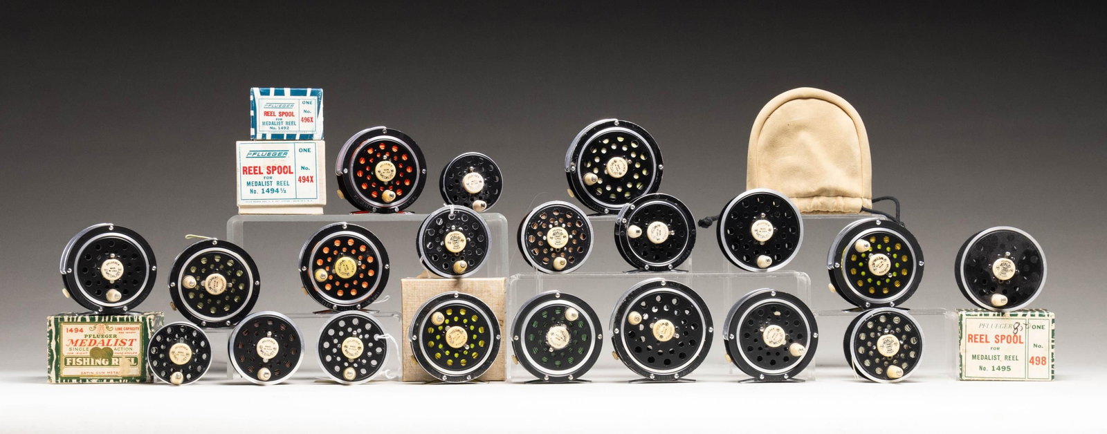 LARGE GROUP OF PFUEGER MEDALIST FLY REELS AND: EXTRA SPOOLS. 1) 12 Pfueger Medalist reels of varying sizes; some with lines. 2) 7 Pfueger Medalist spools of varying sizes; 3 with boxes. CONDITION: generally fine to very fine. PROVENANCE: From the