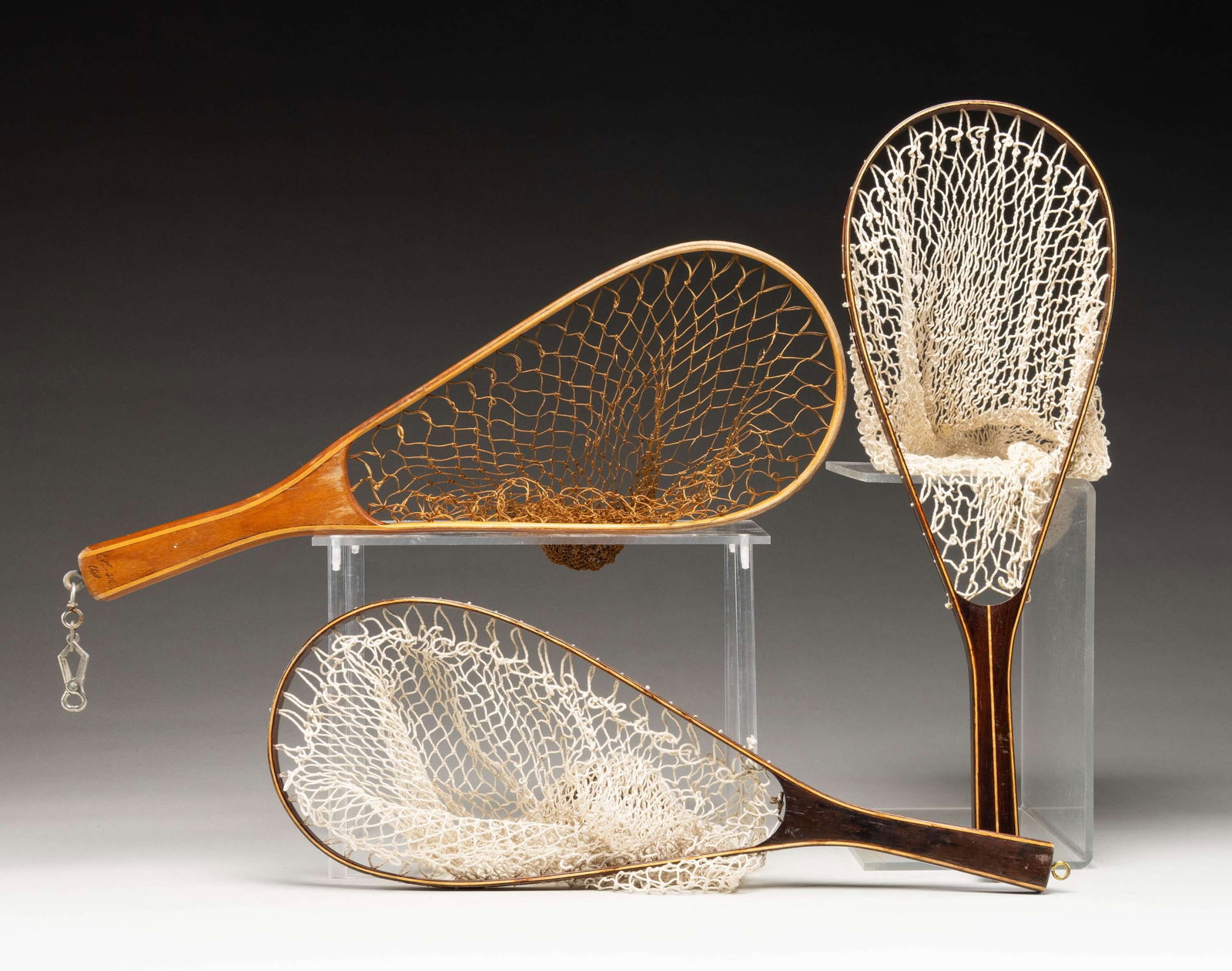 3 LANDING NETS.: 2- Brazilian rosewood and maple laminated 21" (both) landing nets; 1 with central stringer. Both unmarked. CONDITION: very fine; both with good nets. 1- Birch and maple landing net 21". Marked