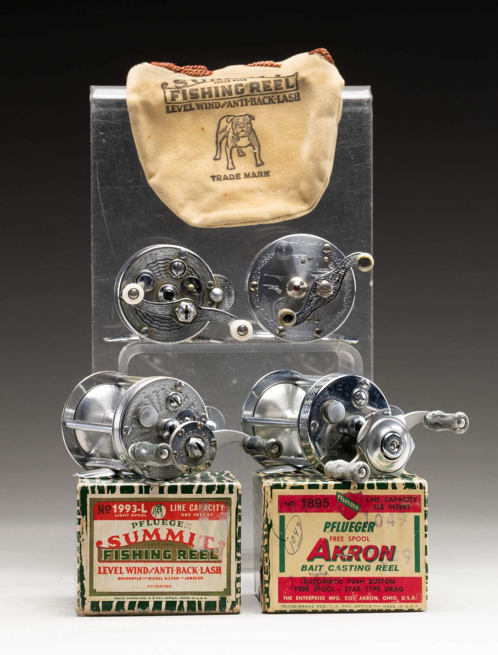 4 BAIT CASTING REELS.: 1) Pfueger "Summit" top of the line, with jeweled pivots and engraved body in box with bag, paperwork and "Comfo Ring". CONDITION: very fine; light wear to plating on top and bottom edges. Comfo Ring
