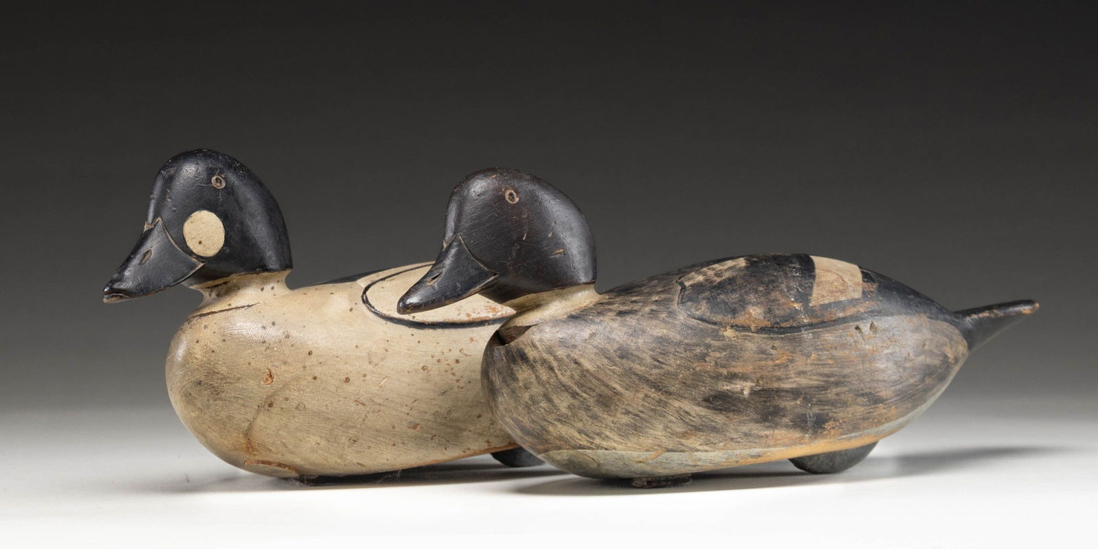 ATTRACTIVE PAIR OF RAISED WING GOLDEN EYE DECOYS.: 1) Hollow bodied drake measures 15" has raised wings and distinctive relief cut around neck with painted eyes. Transition to tail appears stepped. CONDITION: very fine; with old paint having some chip