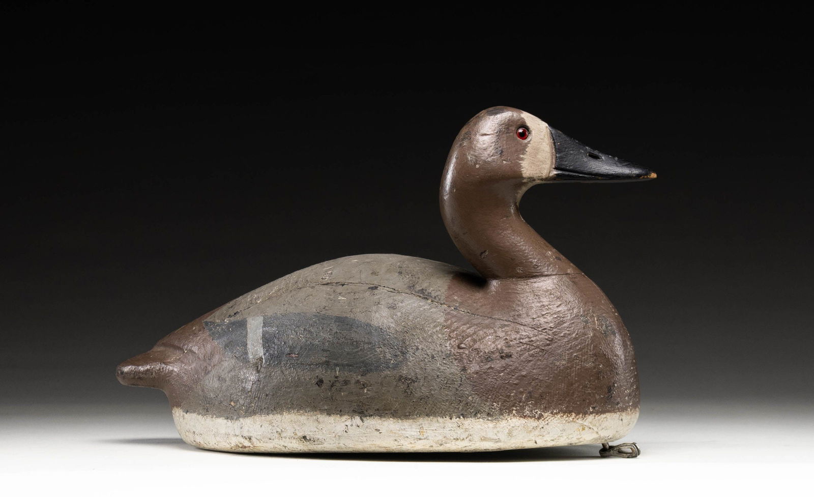 OVERSIZE FRANK STRAY CANVASBACK (?) DECOY.: 17" large solid body stamped "STRAY" on bottom also with owner's mark "ML". Turned head, glass eyes and carved tail. CONDITION: good. Old paint touched up. PROVENANCE: From the Private Collection of B