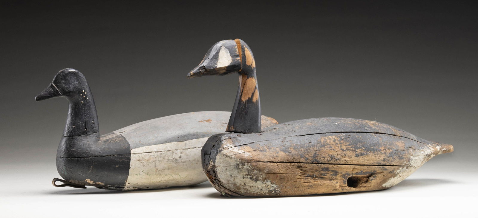 PAIR OF GOOSE DECOYS.: 1) Hollow bodied Brant measures 18-1/2". CONDITION: good. Old repaint with later chips. 2) Old Canada goose measures 22" solid bodied. CONDITION: Body showing considerable wear; head replaced but stil
