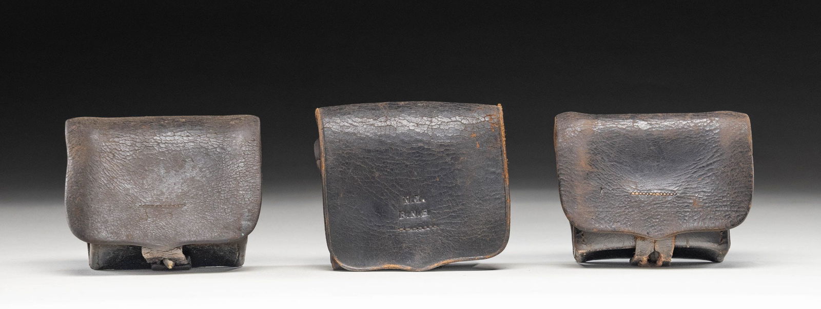 THREE CIVIL WAR U.S. NAVY FUSE BOXES.: 1) Box has a single belt loop with a front flap stamped "N.Y. P.N.H" for Navy Yard Portsmouth New Hampshire. Securing strap is intact, but finial is missing. 2) Box has a single belt loop with a unmar