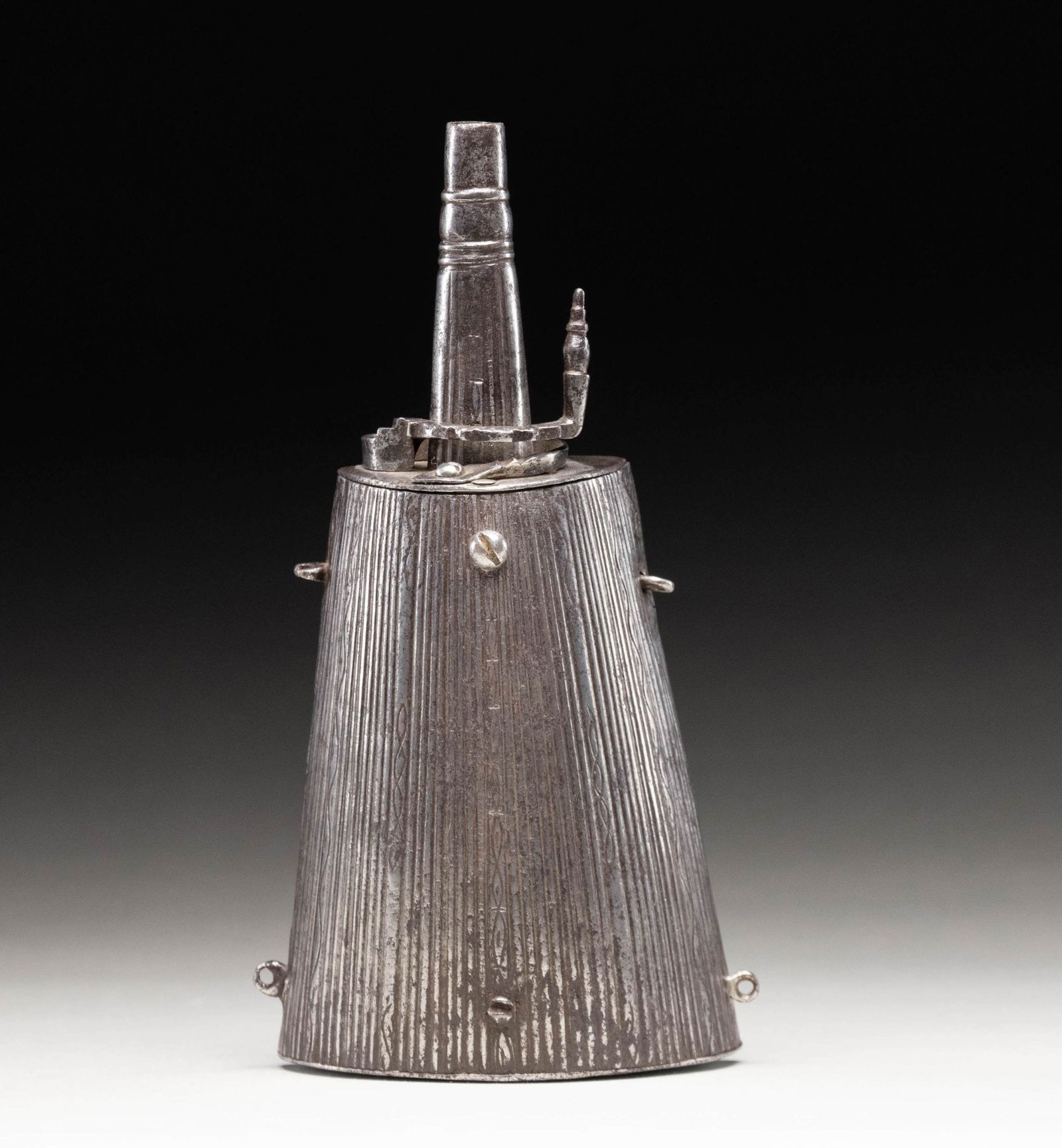 RARE LATE 17TH CENTURY EUROPEON STEEL BODIED: POWDER FLASK. This good looking flask has 5-1/2" half round trapezoidal shaped body incised with many lines and some scroll engraving. A 5" belt hook is affixed to back. Four eyes for attachment of