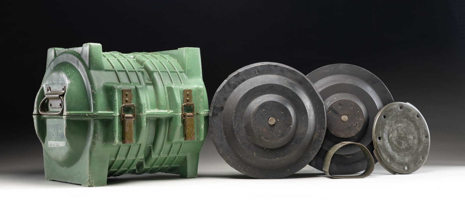 SOVIET TM-62 ANTI TANK PRACTICE MINE LOT.: This lot consists of two inert Soviet TM-62 anti tank practice mines with a 1-88 dated green plastic case. CONDITION: mines show scattered oxidation, paint & age wear. Plastic case shows scattered scu