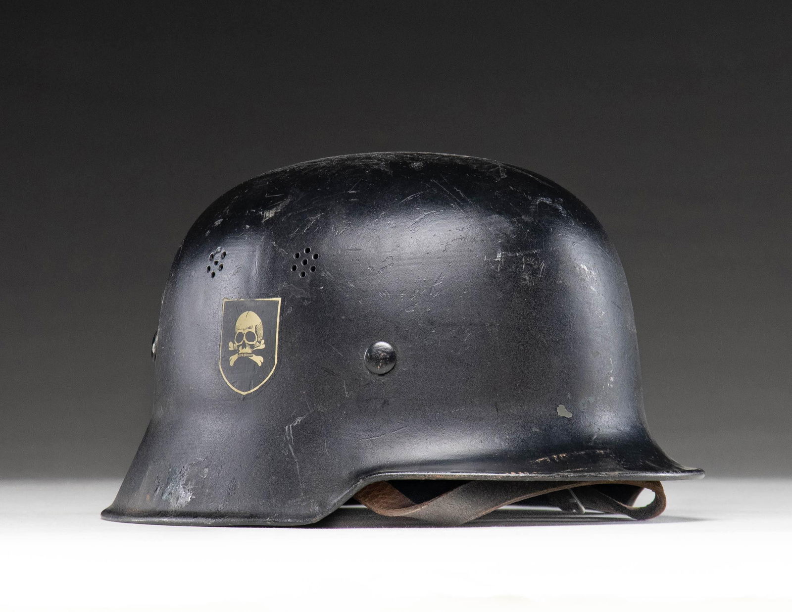 WWII GERMAN POLICE HELMET WITH SS DECALS.: German WWII civic model curved dip Police helmet with a black painted finish. A pair of SS decals were attached to the helmet in the post WWII period but the original Police decal can be seen