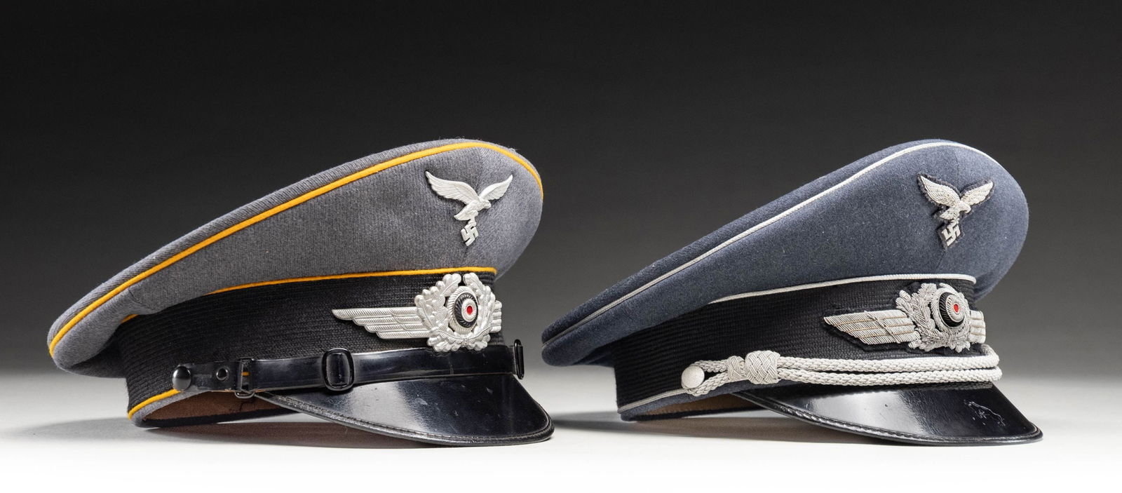 WWII GERMAN LUFTWAFFE ENLISTED AND OFFICER VISOR: CAPS. 1) WWII German enlisted flight branch visor cap. The cap has a gray crown with a black band and is piped in yellow. Aluminum eagle and winged cap wreath. Black visor with green underside. Tan sw