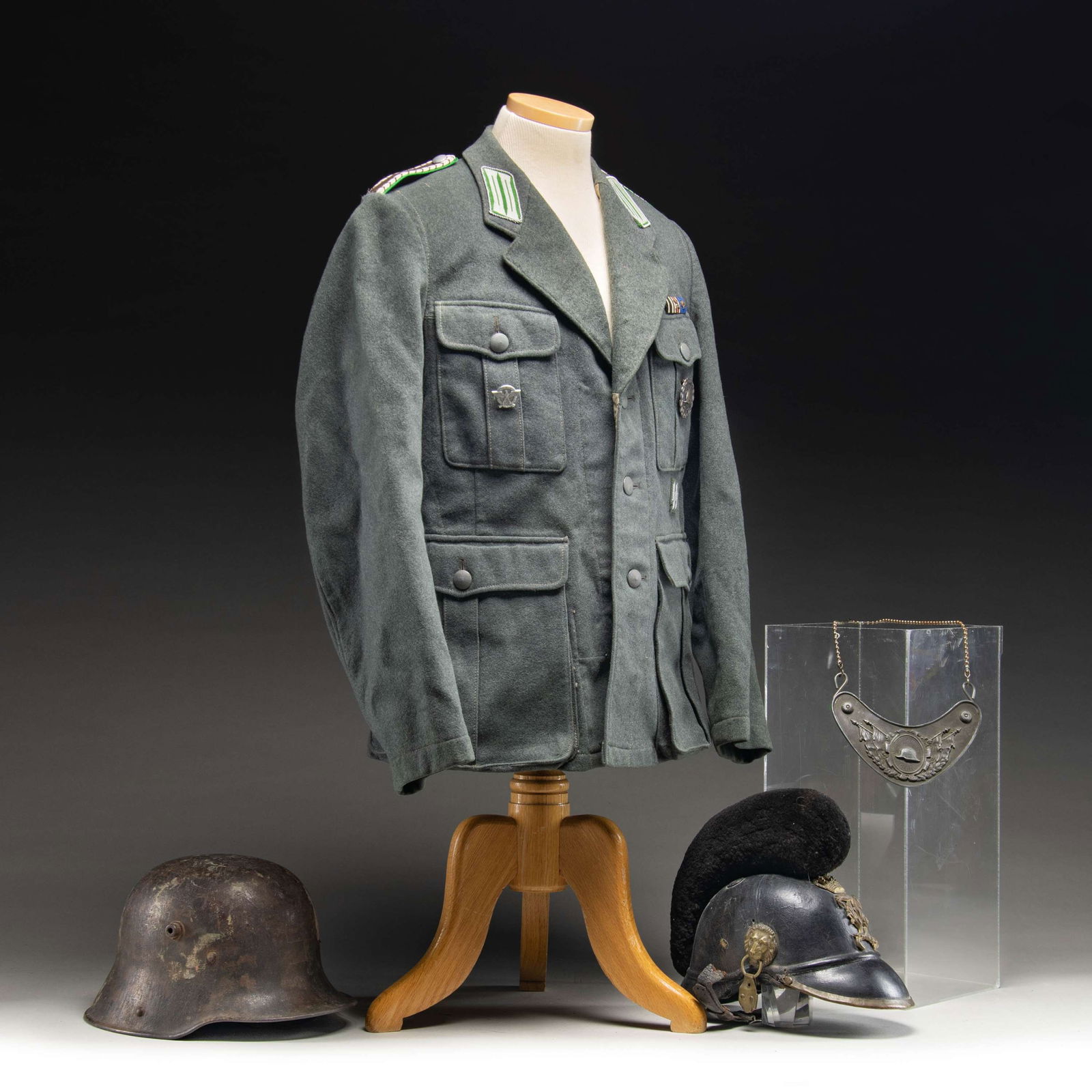 WWII GERMAN POLICE UNIFORM, HELMET, AND MORE.: 1) A fine WWII German Police uniform with brown and silver shoulder straps on a green field. The collar tabs are silver on a green field. The 3 button tunic also has bullion SS runes below the left br