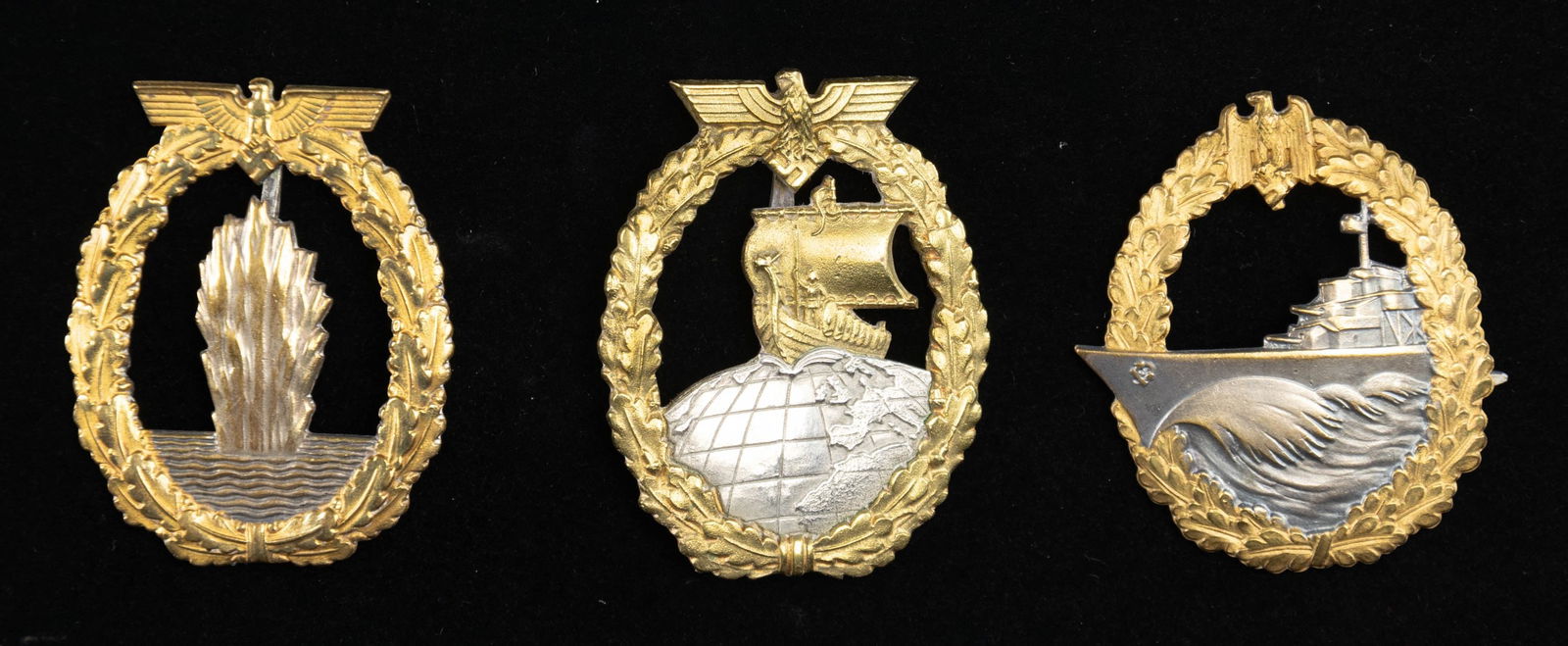 3 WWII GERMAN KRIEGSMARINE BADGES.: 1) A fine example of an Minesweeper Badge with an eagle atop an oak leaf wreath surrounding a spray from an exploding mine. The reverse has a wide pin and is marked "FEC. OTTO PLACZEK BERLIN AUSF. SCH