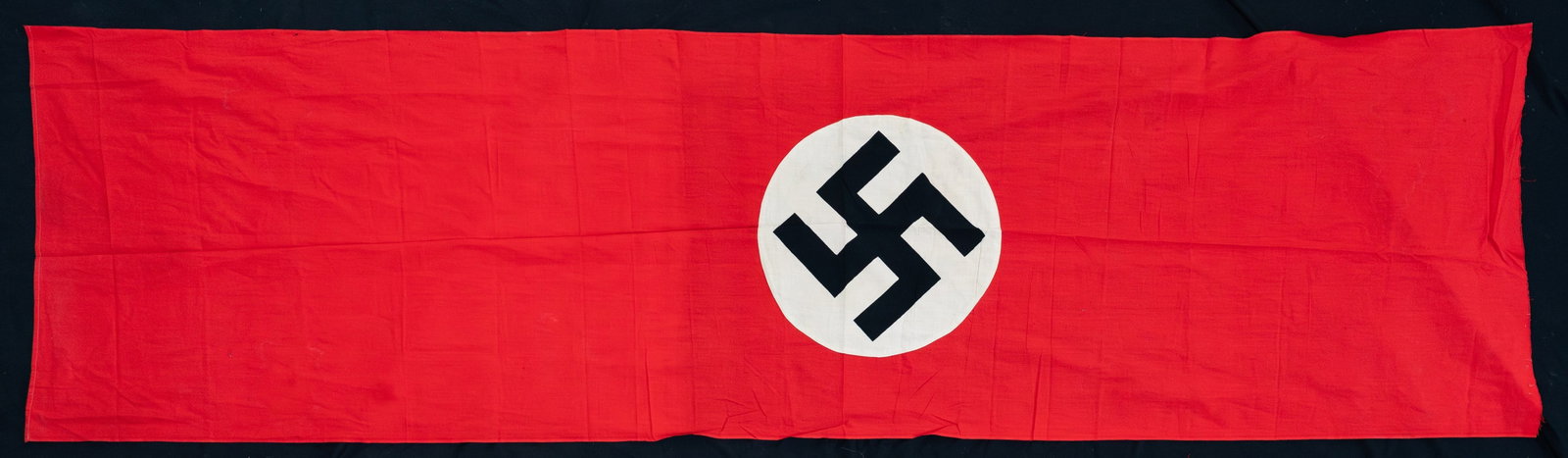 WWII GERMAN PARTY FLAG OR BANNER.: A WWII German party flag or banner measuring about 104" x 28". The flag is made of standard form, style and colors. CONDITION: the flag or banner is in solid condition but is torn across one edge like