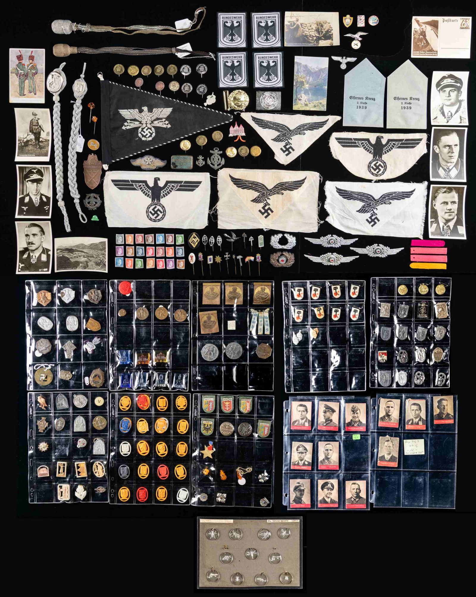 LARGE LOT OF MOSTLY WWII GERMAN PINS, TINNIES,: MINI BOOKS AND MORE. This extensive lot includes a loose leaf binder containing approximately 119 tinnies, pins, WHW items, and related items. The binder further includes approximately 33 "Tag der Weh