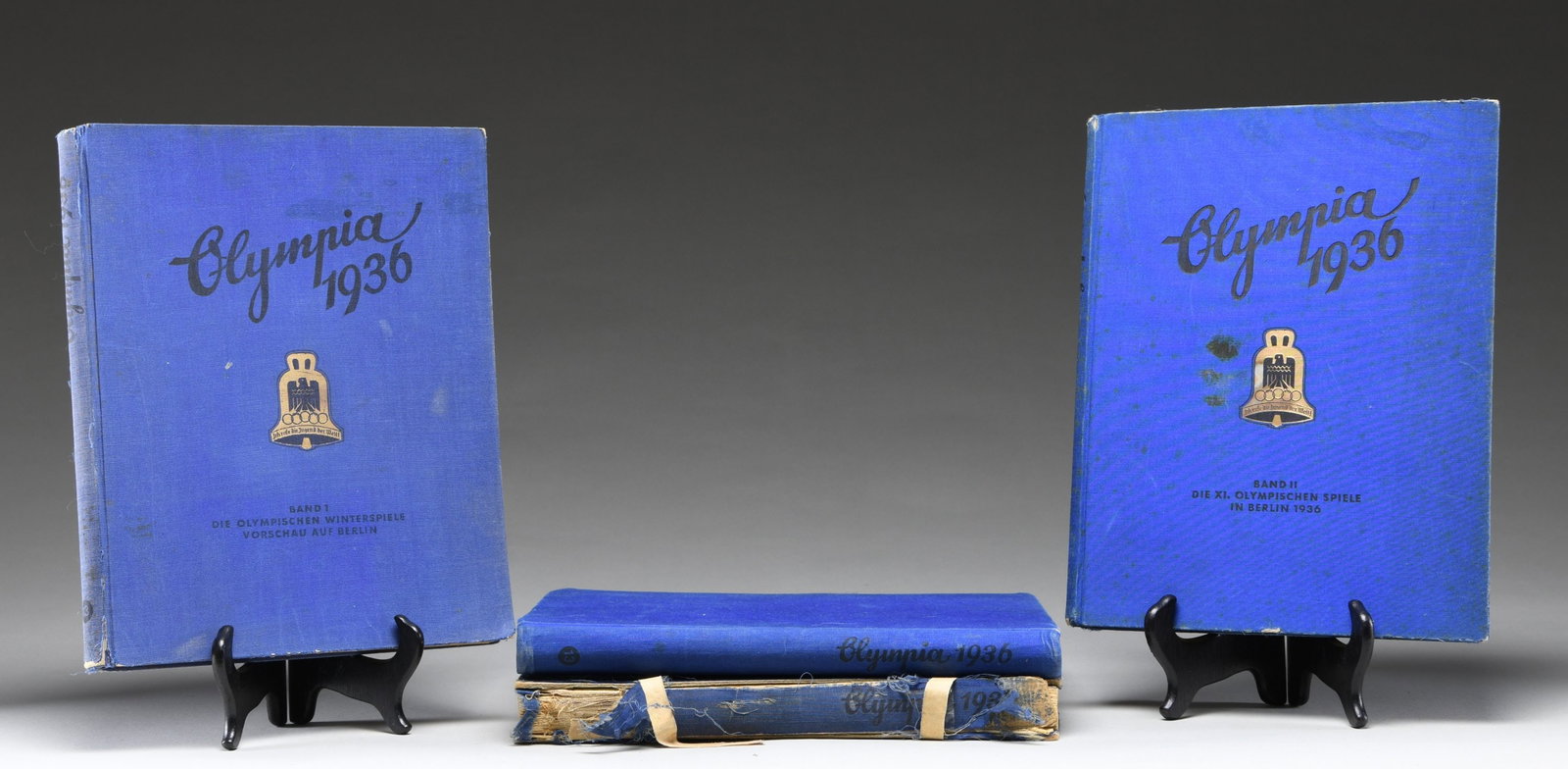 4 GERMAN COMMEMORATIVE PHOTO ALBUMS FOR THE: 1936 OLYMPICS. These books, printed with German text, were illustrated w/ photos which were obtained through the purchase of cigarettes & then glued in their places in the album by the purchaser. The