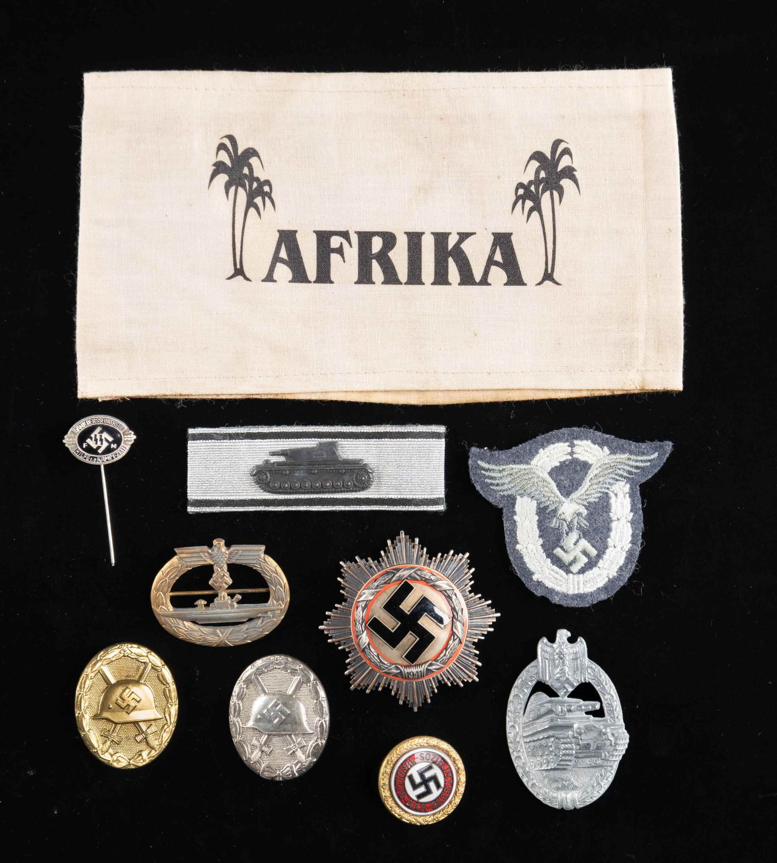 WWII STYLE GERMAN BADGES, PINS, AN ARMBAND & MORE.: This lot contains WWII style German items that we believe to be reproduction. The group includes 1 armband that reads "AFRIKA", 1 German Cross in silver with 6 rivet construction and a wide pin, 1 Sub