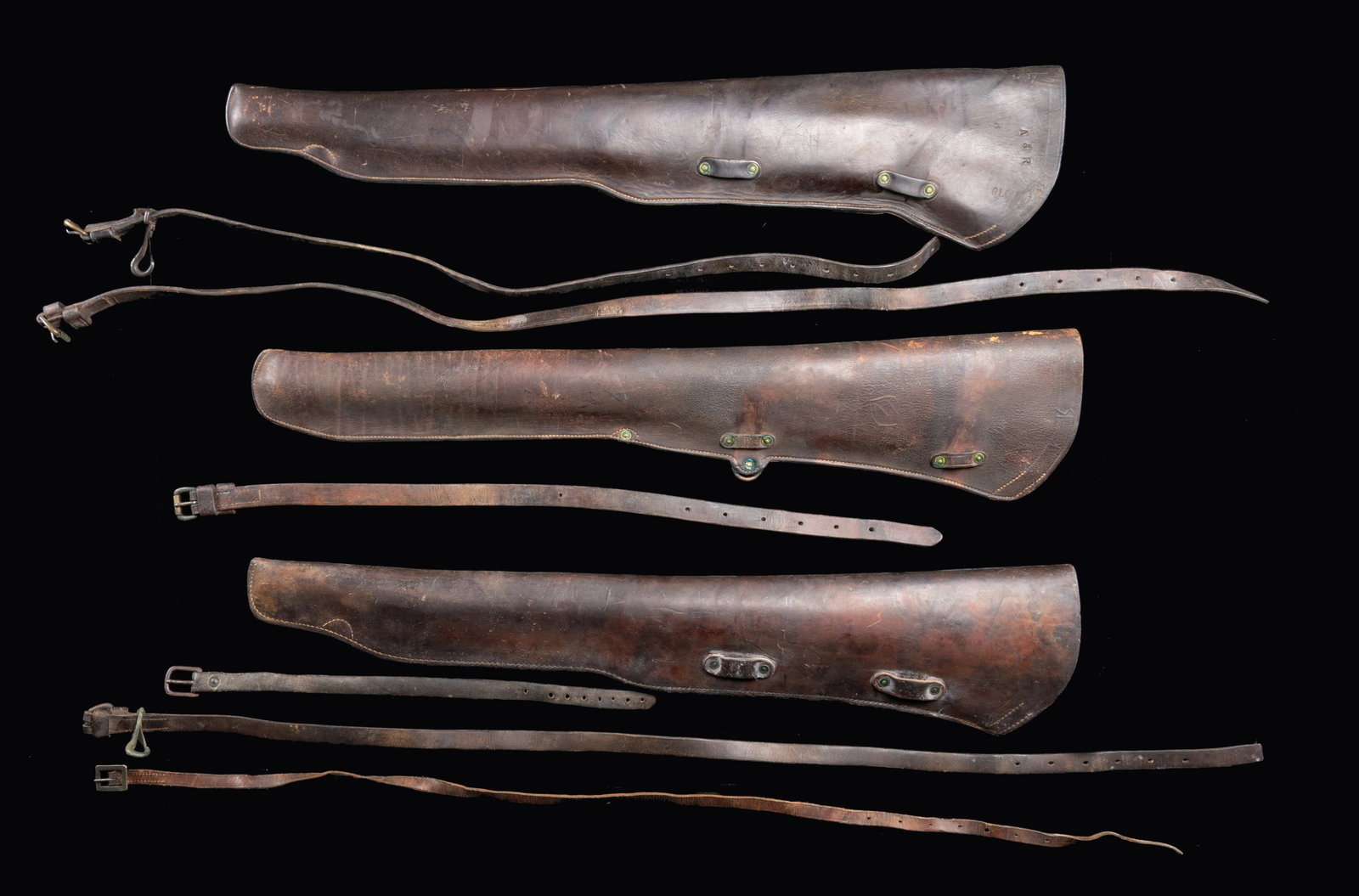 THREE U.S. MODEL 1904 CAVALRY RIFLE SCABBARDS.: These scabbards are for the Model 1903 Springfield bolt-action rifle. Scabbards measure approximately 33 1/2" long & are equipped w/ four loops for the attaching straps. No.1: Brown leather scabbard.