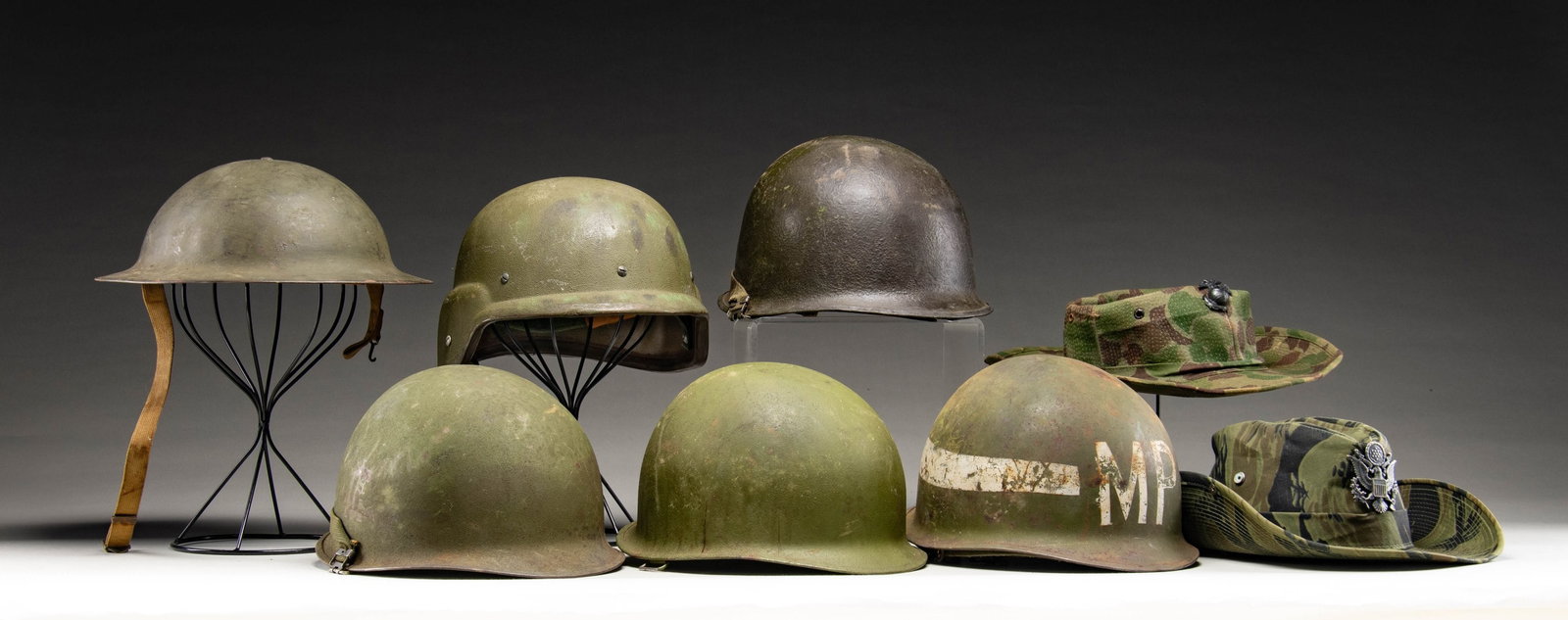 US MILITARY HEAD GEAR.: 1 - M1917 helmet with liner & chin strap; has 1917-1918 GI info.1 - M1 helmet with liner; several broken straps.2 - M1 Helmets with 1 chin strap. 1 "MP" M1 Helmet with liner & chin strap. 2 Bush