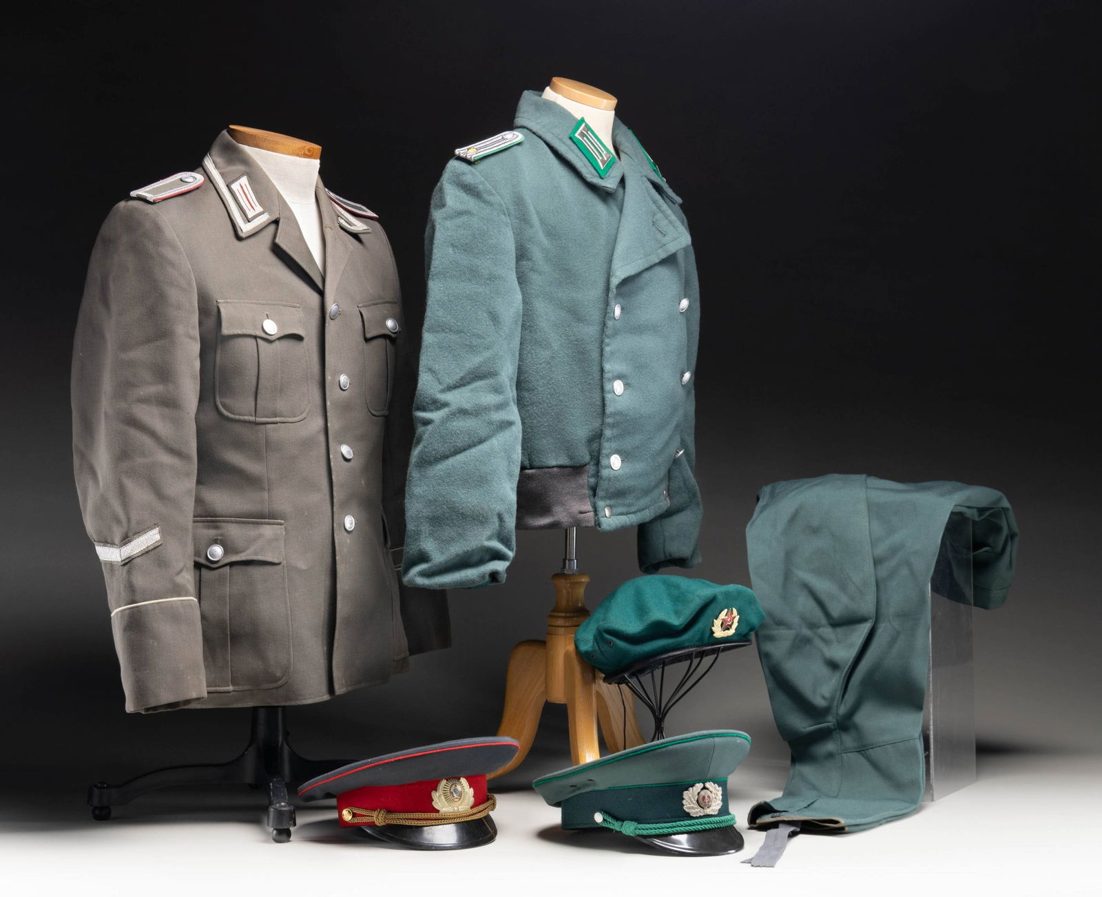 EAST GERMAN UNIFORMS AND VISOR CAPS.: This lot contains 1 East German green wool double breasted jacket for a 1st Lieutenant with green backed collar tabs and shoulder boards, 1 Pair of wool / polyester blend green pants, 1 Brownish green