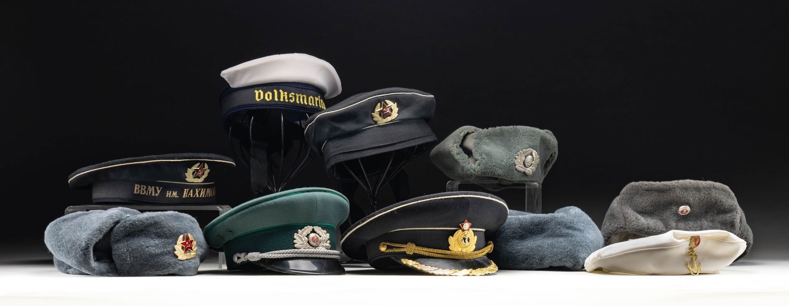 LOT OF COM-BLOC HEADGEAR.: This lot consists of 8 varied Cold War era Com-Bloc hats mostly East German & Russian. Hats appear to be a mix of both army & navy. CONDITION: one East German naval cap is missing much of its top. Oth
