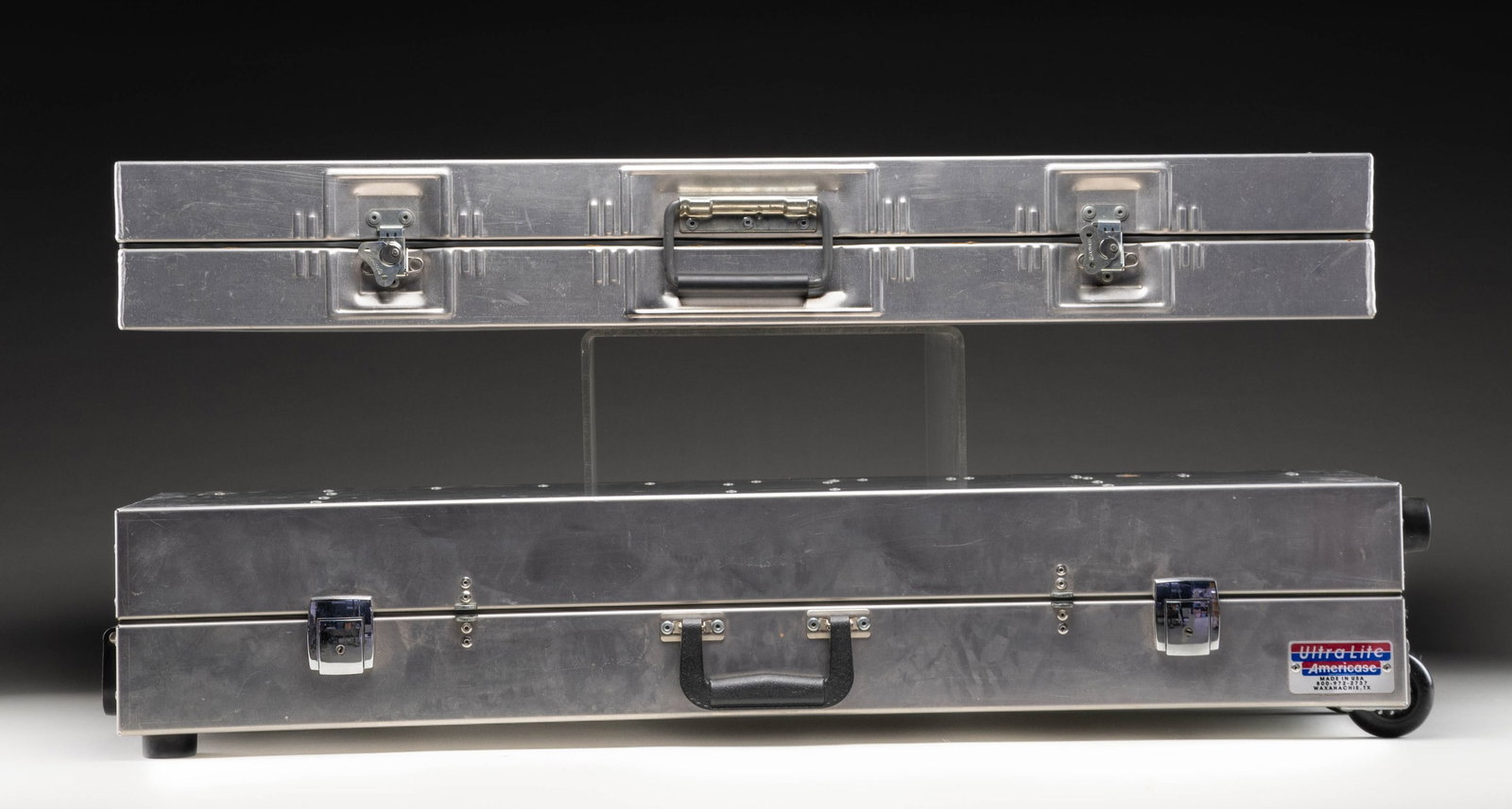 2 ALUMINUM HARD CASES.: 1 Ultra-Light Americase for 2 shotguns; 37" x 9" x 7". Case appears very good with light wear.1 Unmarked case; 38" x 14" x 5". Case is missing key & is locked, unable to open. PROVENANCE: From the Pri