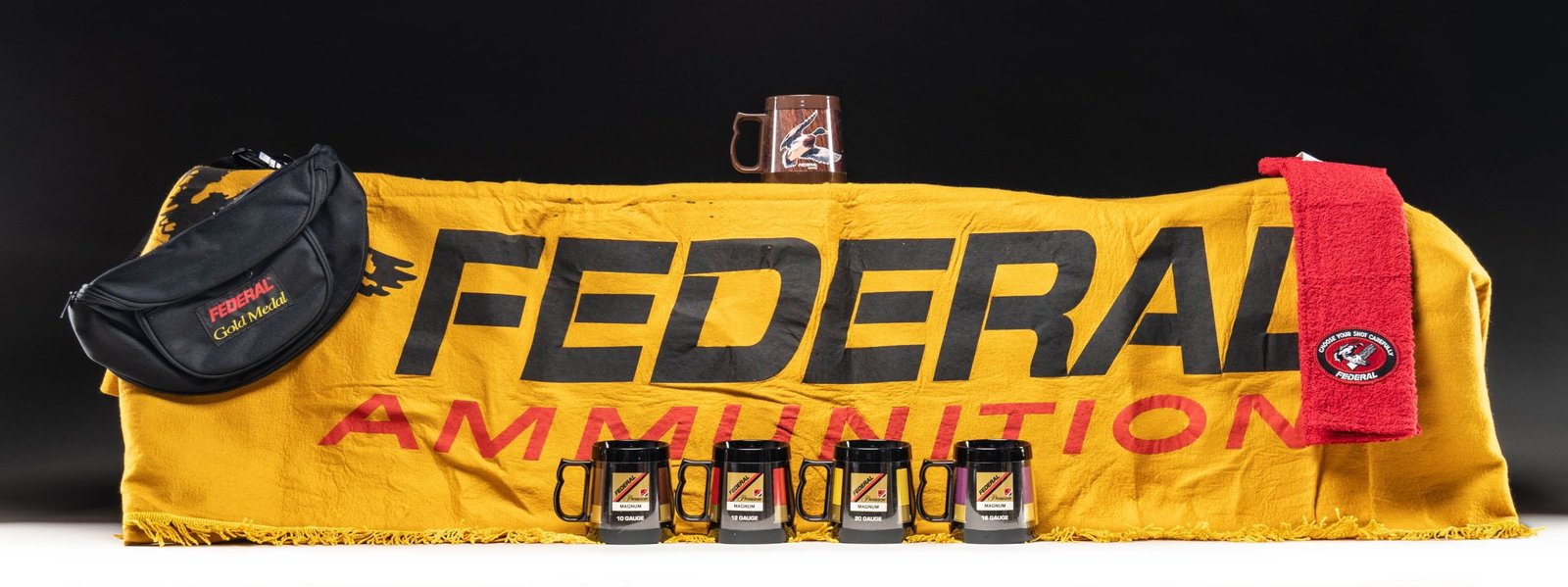 LOT OF ASSORTED FEDERAL AMMUNITION MEMORABILIA.: Lot of assorted Federal ammunition memorabilia, including: 1) x1 Federal brown plastic wood grain mug in cardboard box. 2) x1 set of 4 Federal black plastic shotgun shell coffee cups in cardboard box.