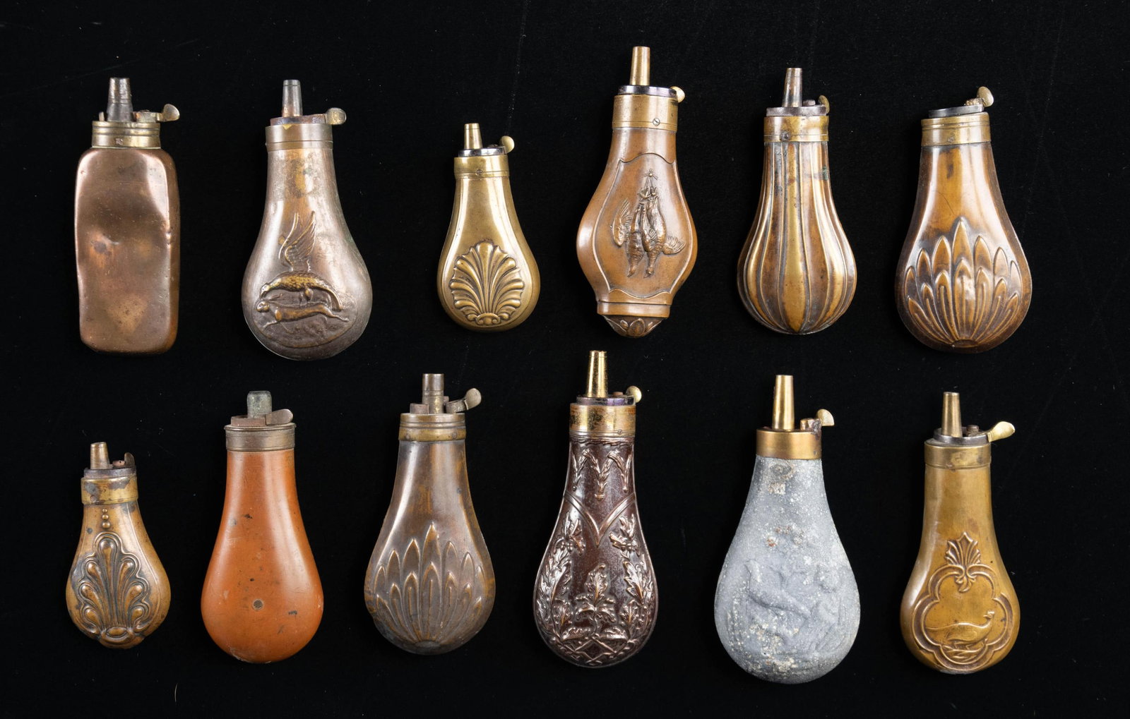 TWELVE PISTOL POWDER FLASKS.: Mostly 3"-4", includes flasks labeled Riling 121, 122, 307, 247, 303, 323, 343, 562, 584, 709, 710. CONDITION: good overall, 122-dented, 343 missing charger. (02-25907/JS). NON-GUN. $800-1,200.