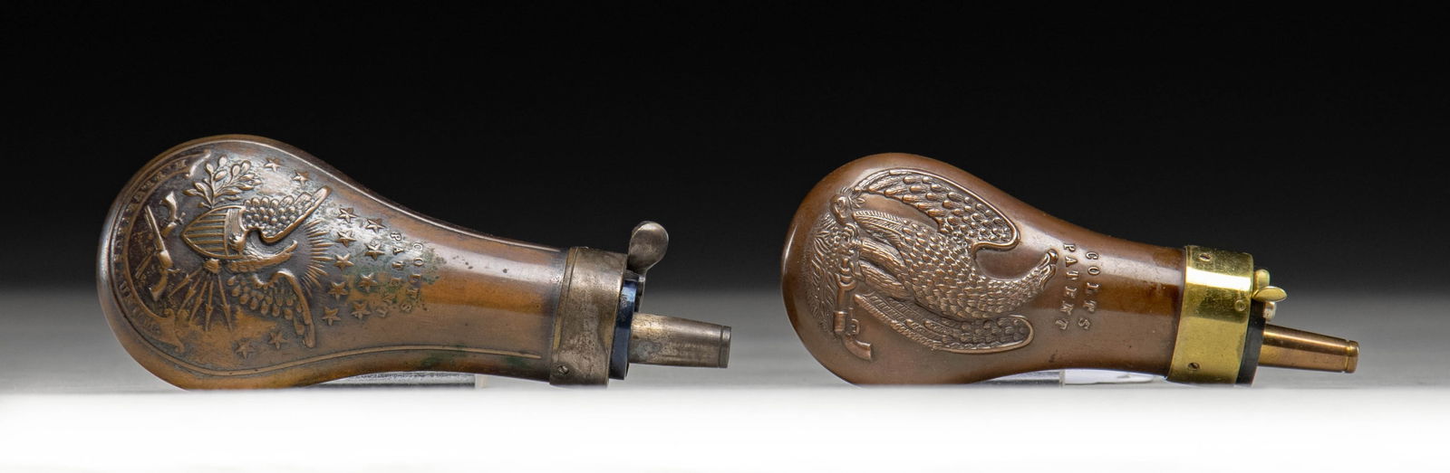 TWO COLT EAGLE PISTOL POWDER FLASKS.: 4.5" single sided eagle (tagged Riling 809), 4.25" double sided eagle flask (tagged Riling 805) charged marked "Made in England / Dixson & Sons". CONDITION: very good. (02-25909/JS). NON-GUN.