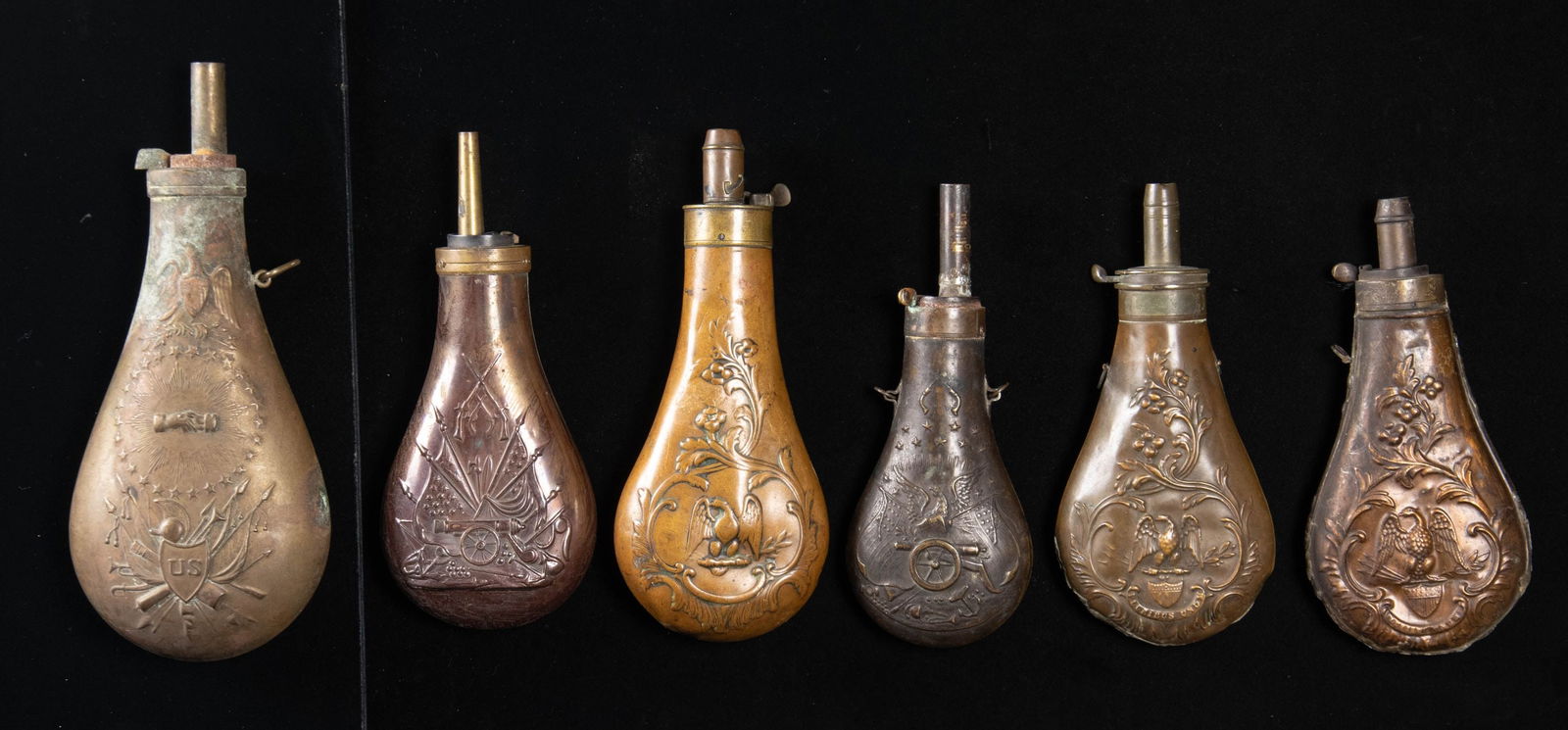 SIX EAGLE POWDER FLASKS.: Mix of reproduction and original flasks, labeled Riling 779, two 796, 798, 820, 859. CONDITION: fair to good, several with open or re-soldered seams. (02-25911/JS). NON-GUN. $600-900.