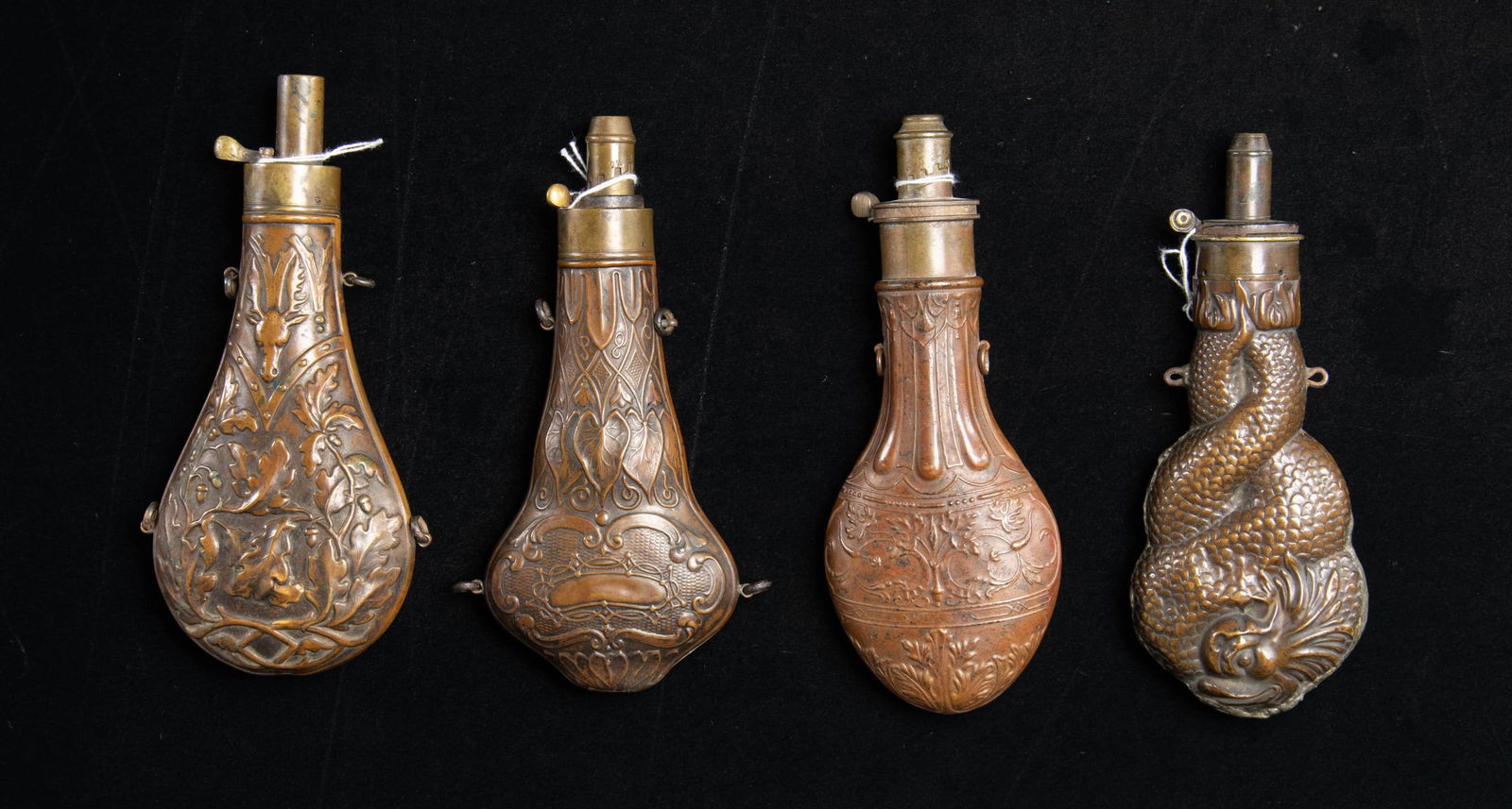 FOUR LARGE DECORATED POWDER FLASKS. - 2