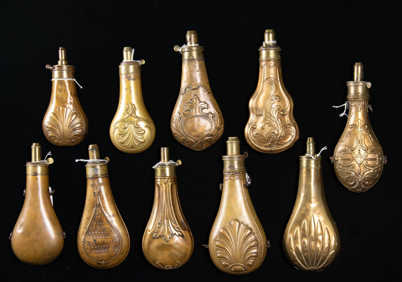 TEN DECORATED HUNTING POWDER FLASKS.: 1) 9" clamshell, Riling 388. 2) 8" Hawksley, Riling 662. 3) 9" Riling 366. 4) 8" Bartram, missing part of charger. 5) 8" Riling 540, dented. 6) 7" Riling 372. 7) 8" Hawksley, Riling 527. 8) 8.5"