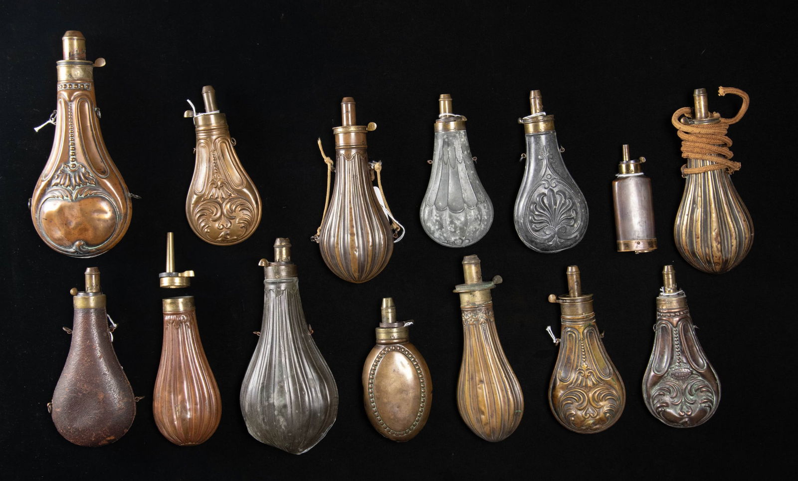 FOURTEEN DECORATED HUNTING POWDER FLASKS.: 1) 7" "W. POWELL & SON-BIRMINGHAM", looks like Riling 504 but this one marked. 2) 7" zinc, Riling 338. 3) 7" zinc, Riling 262. 4) 10" Dixson, Riling 558. 5) 8.25" American Flask Co, Riling 296. 6)