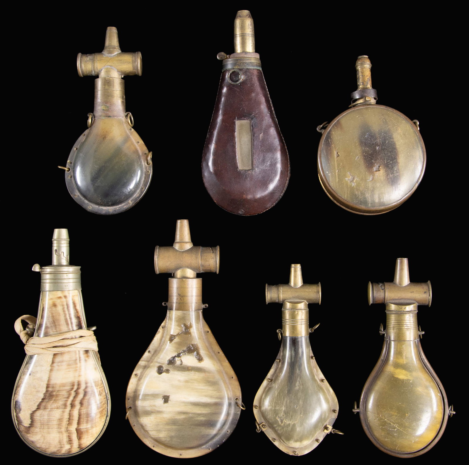 SEVEN SCARCE BRASS BOUND EARLY HORN POWDER: HORNS. Four have the early cylindrical chargers often associated with Paterson shotguns & rifles, 6.5" to 8". 7" leather covered with cut-out windows to see powder levels, 8" white metal bounded, 4"