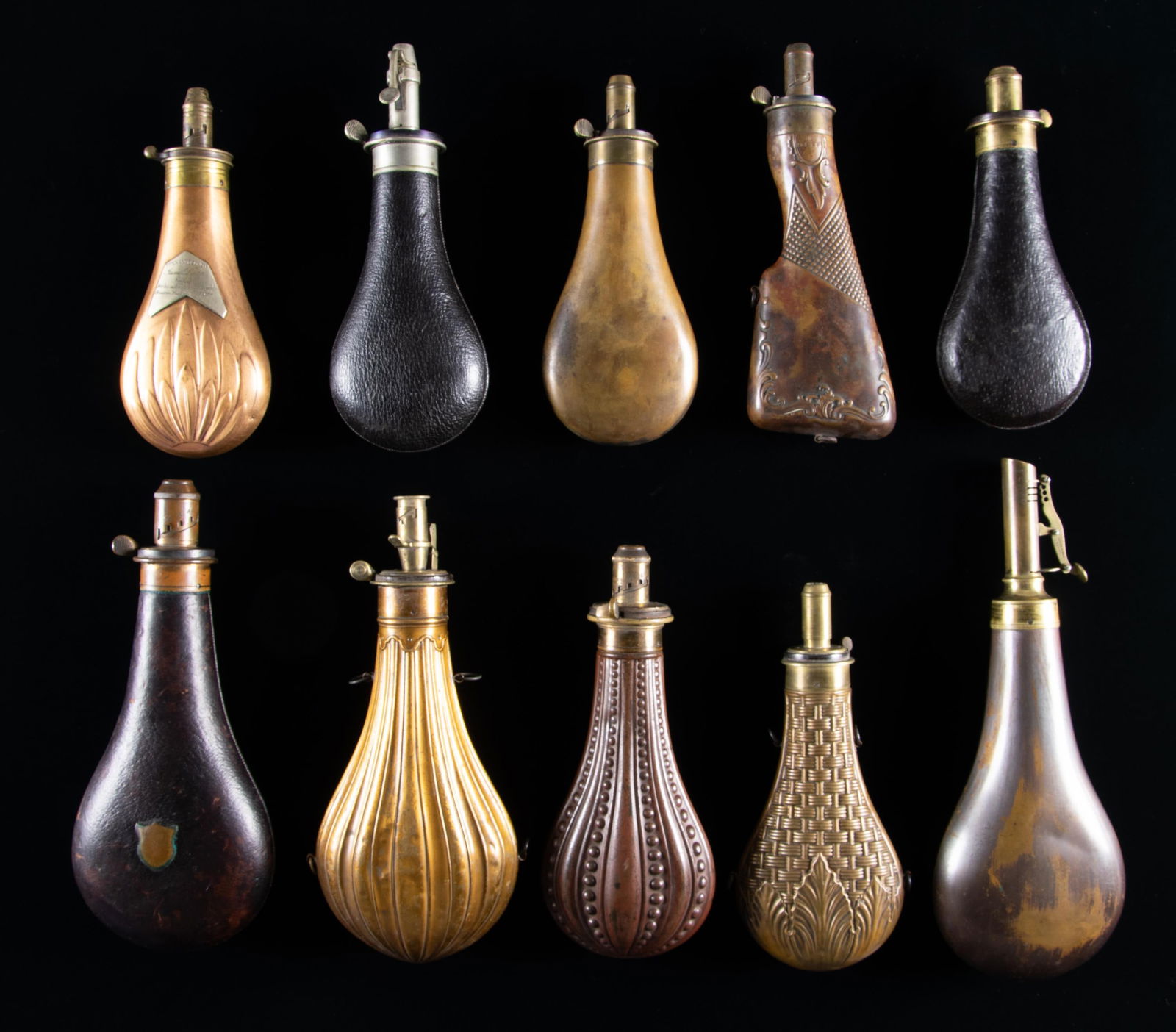 FINE GROUP OF 10 DIFFERENT JAMES DIXON RIFLE &: SHOTGUN POWDER FLASKS. 10.5" embossed design with patent charger, 8" 1836 presentation flask, 8.5" embossed rifle stock, 8" with applied round embossed rooster & "LIRETY", 8" & 9" & 10" leather covere