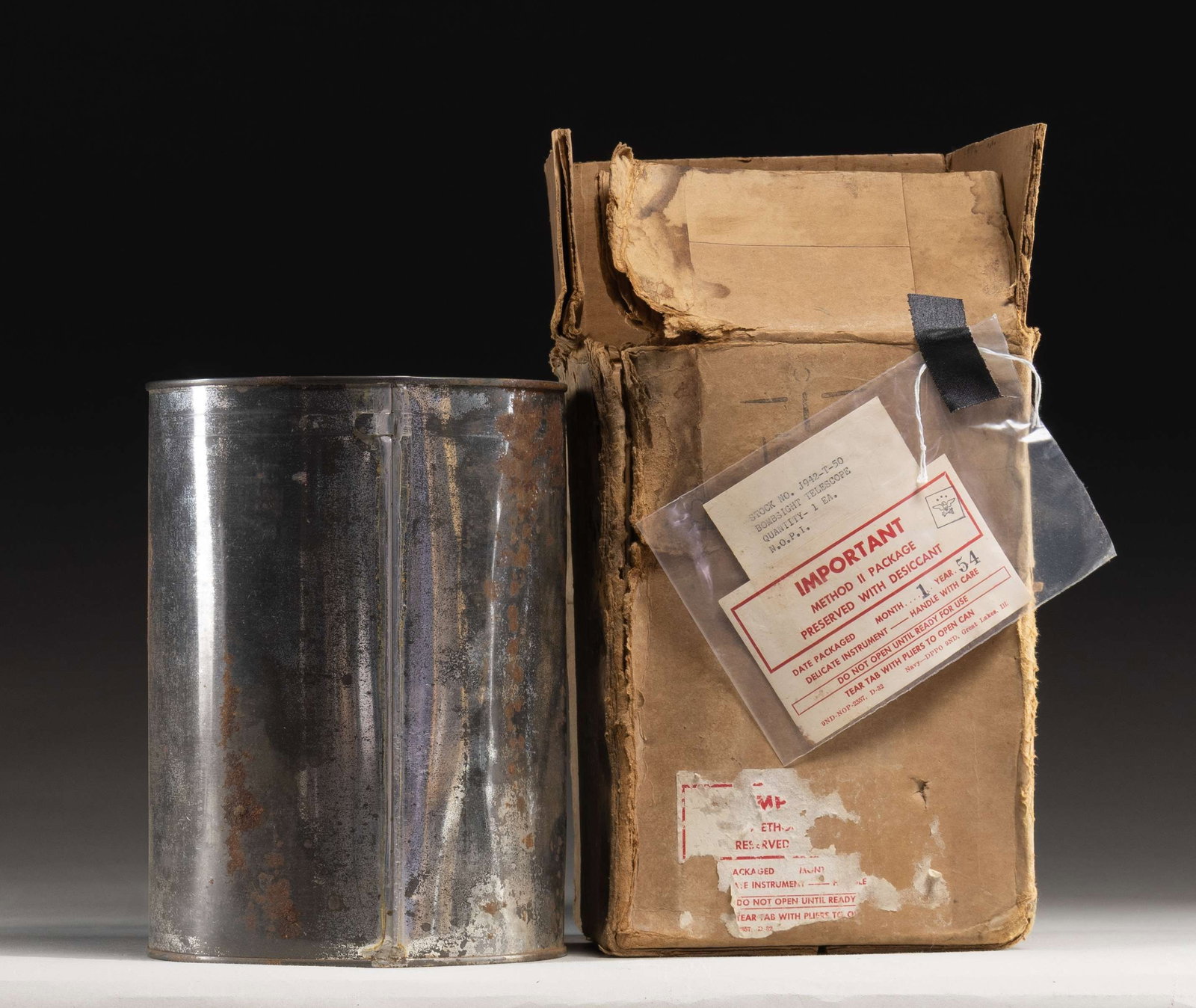 NORDEN BOMBSIGHT.: WW2 era Nordnen Bombsight. Sight is sealed metal shipping container & includes a 1954 dated DOD shipping box in poor condition. Box has label with stock number "J942-T-50". CONDITION: container has