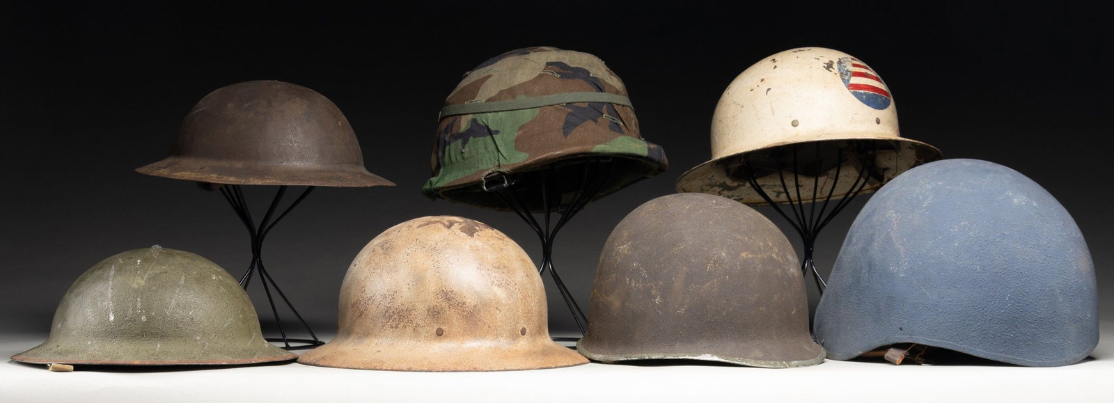 LOT OF PRIMARILY U.S. MILITARY HELMETS.: Lot of primarily U.S. military helmets, including: 1) U.S. WWI era (1917) Brodie helmet. OD sawdust textured painted exterior, with brown leather liner, and riveted khaki canvas chin straps. Interior