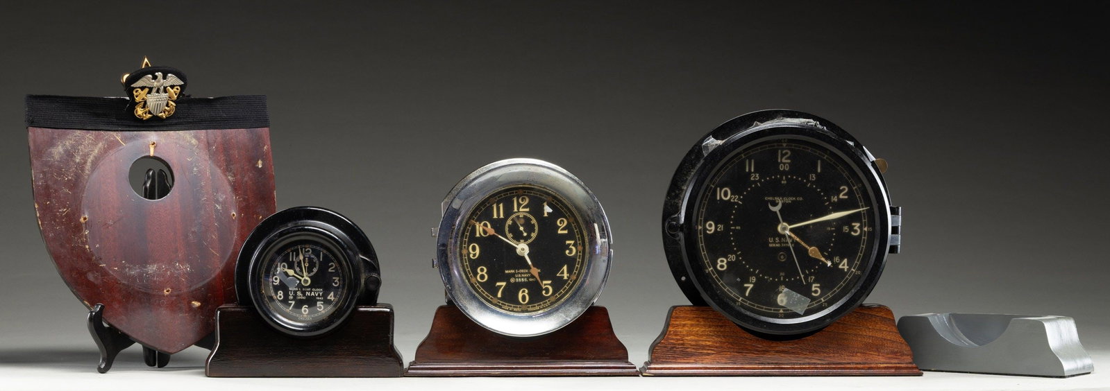 US NAVY CLOCKS & STANDS: Lot includes:1 - US Navy Mark I Deck clock w/ wind up key.1 - US Navy Mark I Boat clock.1 - Chelsea Clock Co. US Navy clock w/ wind up key.4 desk stands & 1 wall mount. 4 wind up keys. CONDITION: