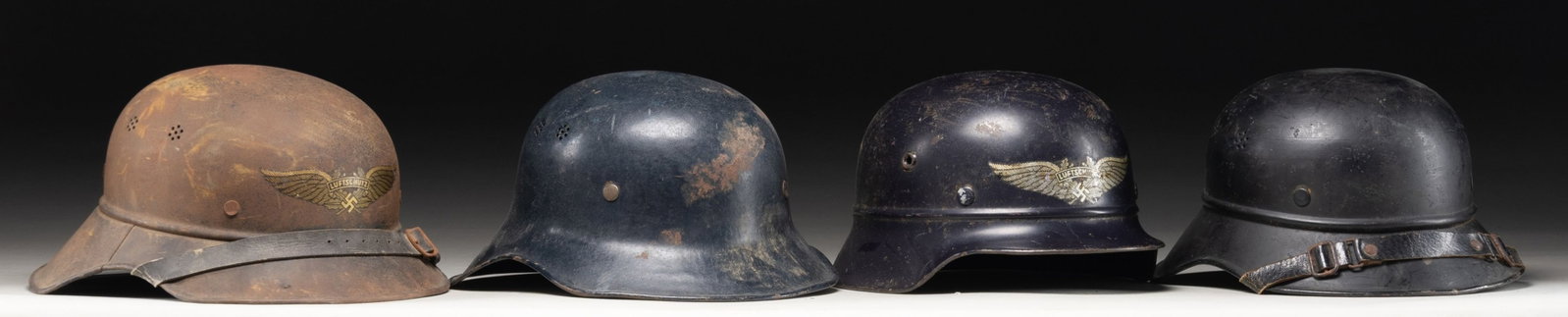 4 WWII GERMAN LUFTSCHUTZ HELMETS.: This lot of 4 WWII German Luftschutz helmets include 1 Three piece style with a decal on the front and interior markings, 1 Two piece style with a decal on the front but no interior markings, 1 Two