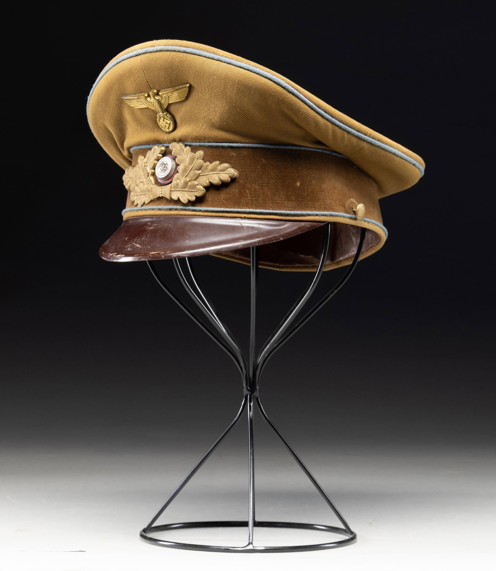 WWII GERMAN POLITICAL LEADER'S VISOR CAP.: A good original WWII German Political Leaders visor cap for an orts level leader. Cap has a dark tan crown with a brown velvet band all piped in blue denoting orts level. The front of the peak has a