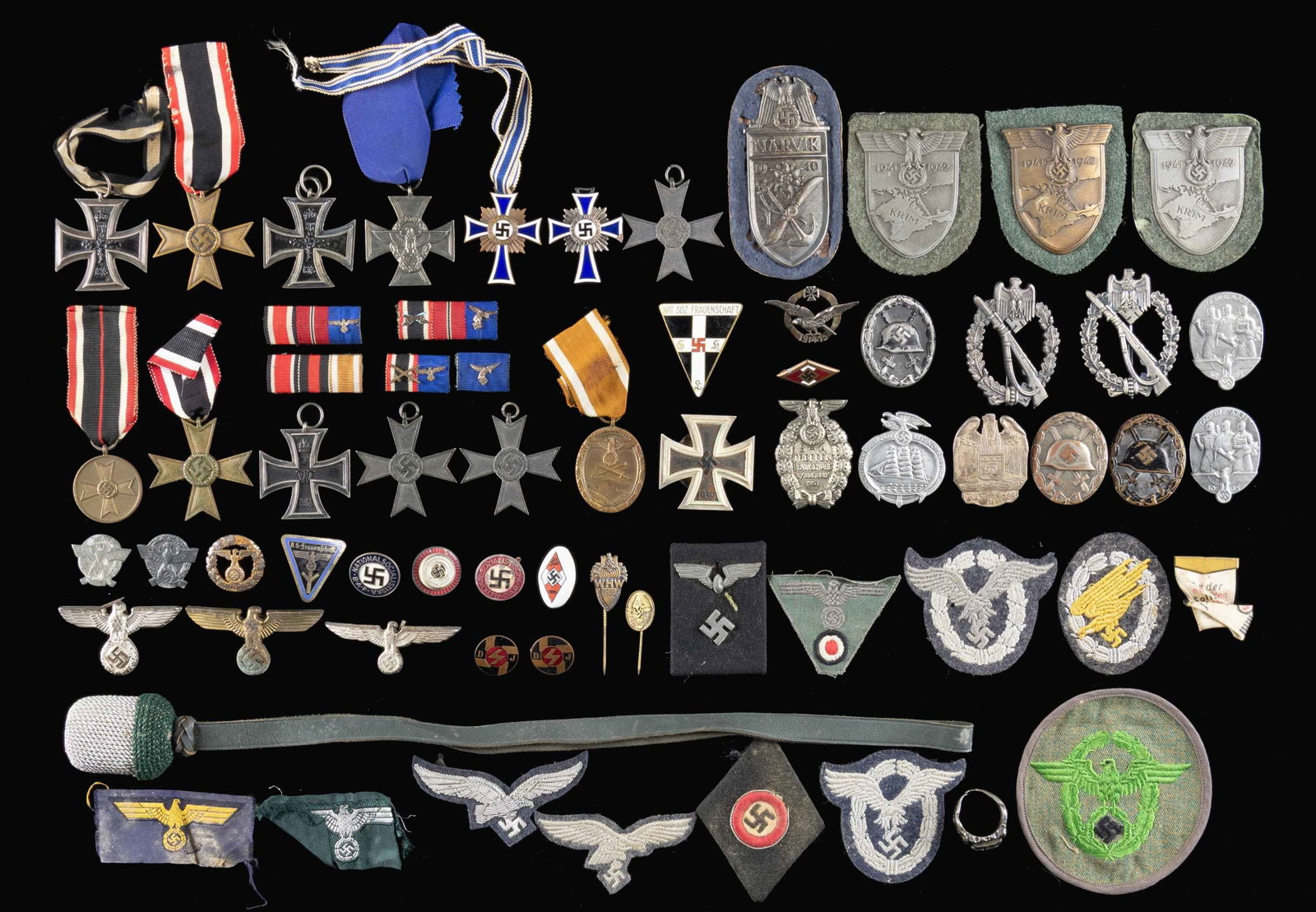 LARGE ASSORTMENT OF WWII GERMSN MEDALS, BADGES,: INSIGNIA, PINS AND MORE.This large group contains 2 WWI Iron Crosses with out ribbons, 3 Krim sleeve shields with cloth backing (moth damage), 1 Narvik sleeve shield with cloth backing (heavy moth dam