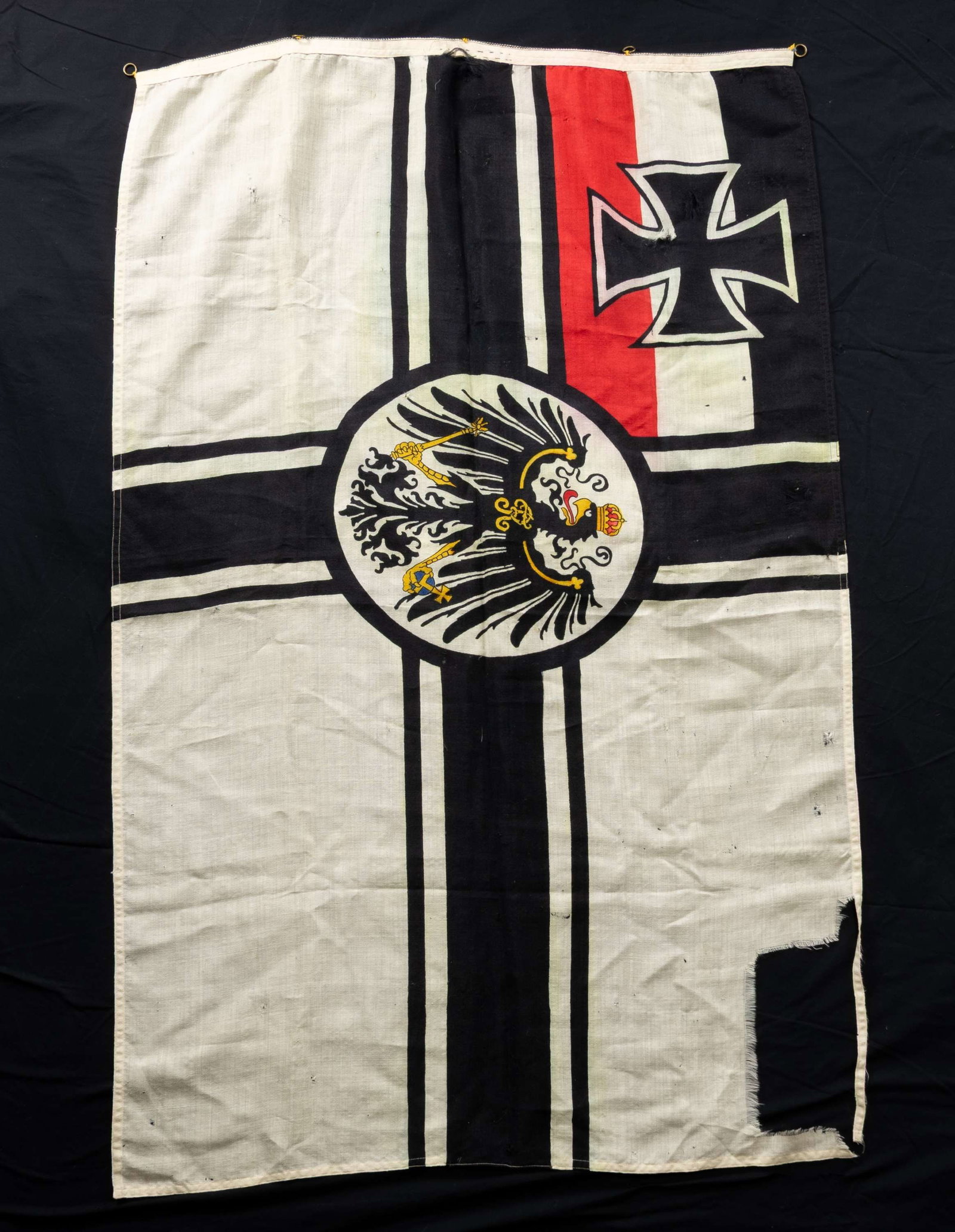 WW1 IMPERIAL GERMAN FLAG.: This is an original WW1 Imperial German flag. It measures 3' x 4 1/2' CONDITION: there is a large portion missing from the upper outside corner, numerous small holes and scattered staining. (02-26672/