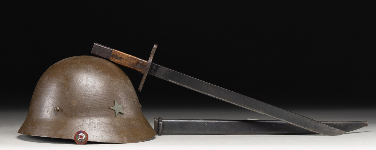 WWII JAPANESE MILITARIA GROUPING.: 1) JAPANESE ARMY T90 STEEL HELMET. Contains it's original liner. 2) TOYADA JIDOSHOKI SEISAKUSHO UNDER NAGOYA. Blued blade, straight quillon, wrap around grip, & rectangular pommel. Metal scabbard.