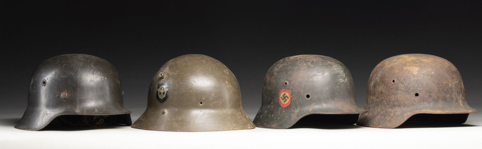 LOT OF 4 GERMAN M35, M40, M42, & CZECH M30: HELMETS. Lot of 4 German M35, M40, M42, and Czech M30 helmets, including: 1) German Pre-War / WWII double decal M35 stahlhelm. Helmet exhibits a gray painted finish featuring a shielded Third Reich in