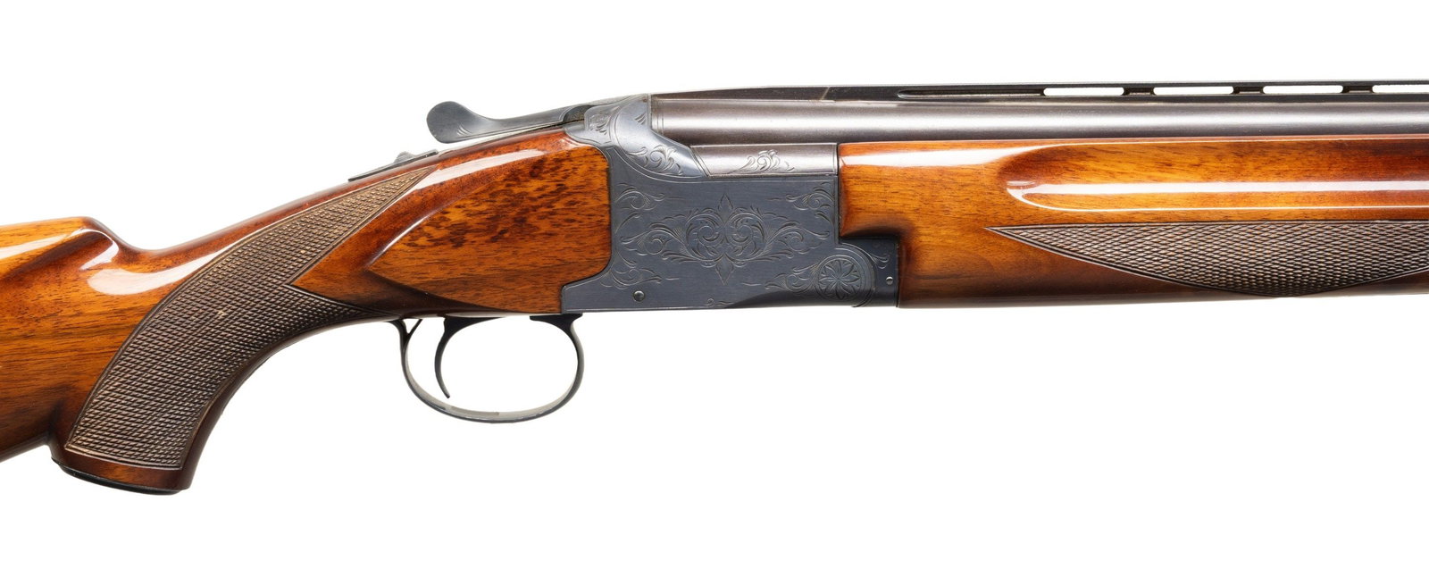 WINCHESTER 101 O/U SHOTGUN.: Cal. 12 Ga., 2 3/4". S# K173220. Mfg. in Japan by Olin Kodensha. VR 26" bbls. w/ brass bead; Mod. over Imp. Cyl. chokes. Blued boxlock action with scroll engraving. Checkered walnut stock set. CONDITI